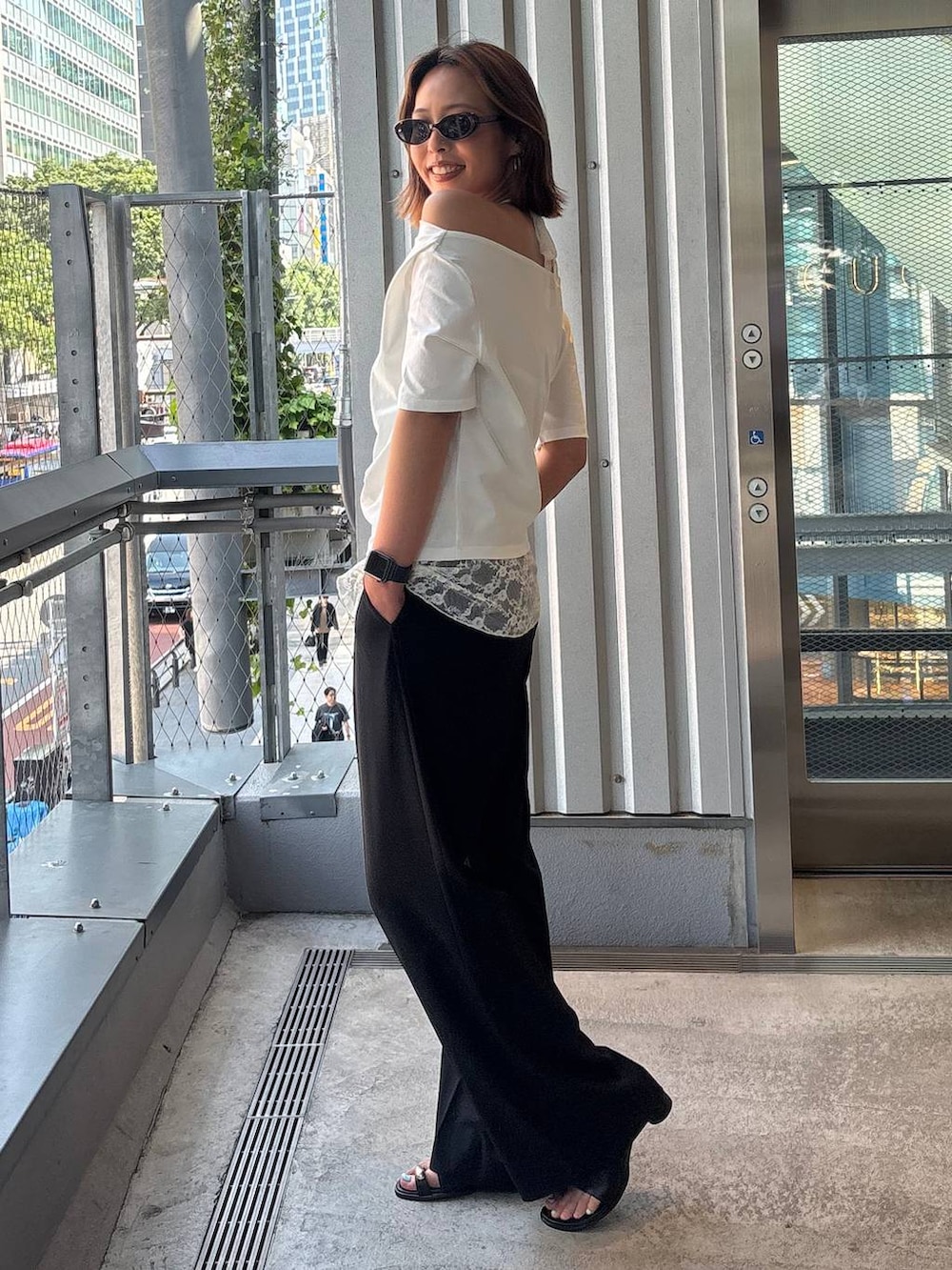ブラック系のその他パンツ、ブラック系のサンダル、ホワイト系のTシャツ/カットソーを着用したレディースの春コーディネートの3枚目の写真