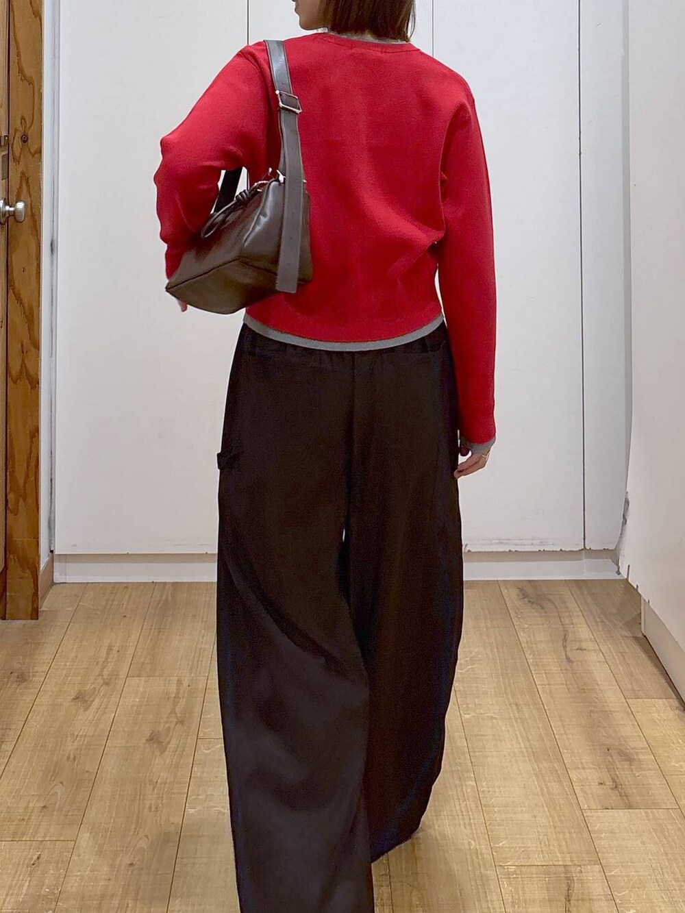 ブラック系のローファー、レッド系のカーディガン/ボレロ、ブラウン系のショルダーバッグを着用したレディースの冬コーディネートの7枚目の写真