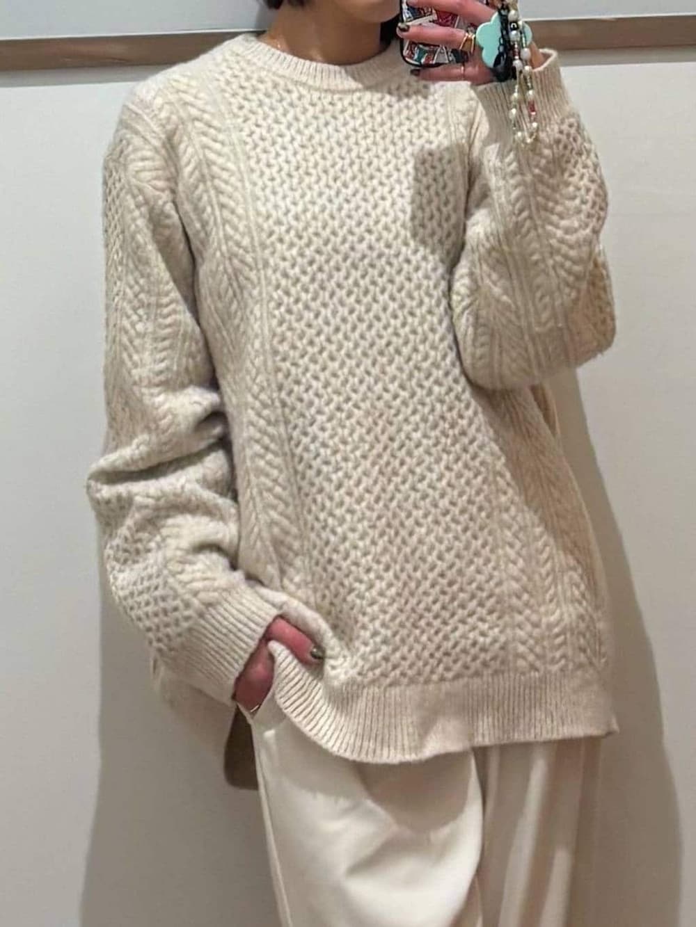 ホワイト系のニット/セーター、グレー系のその他パンツ、ブラック系のブーツを着用したレディースの冬コーディネートの5枚目の写真