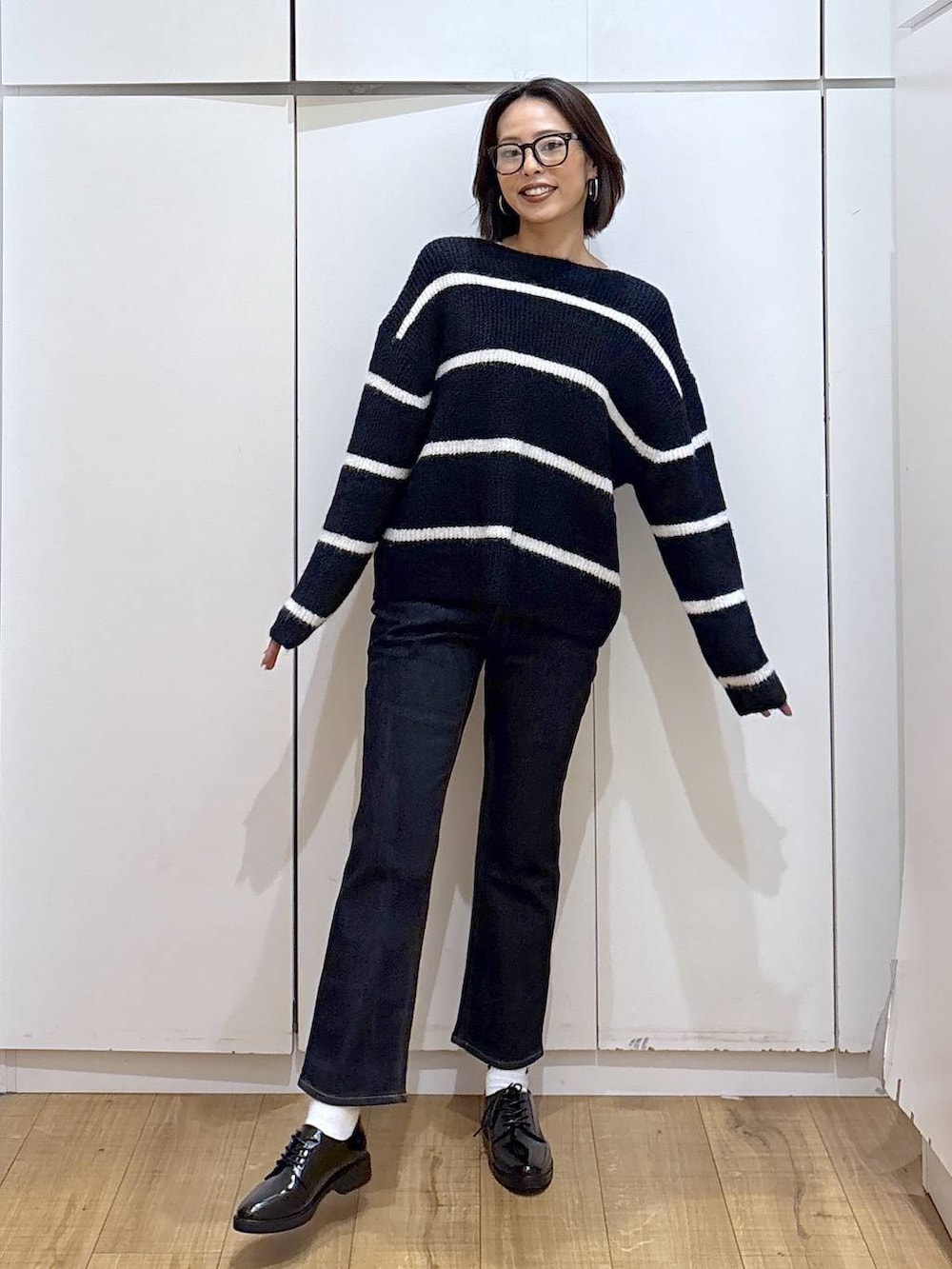 ベージュ系のダウンジャケット/コート、ブルー系のデニムパンツ、ブルー系のニット/セーターを着用したレディースの秋コーディネートの5枚目の写真