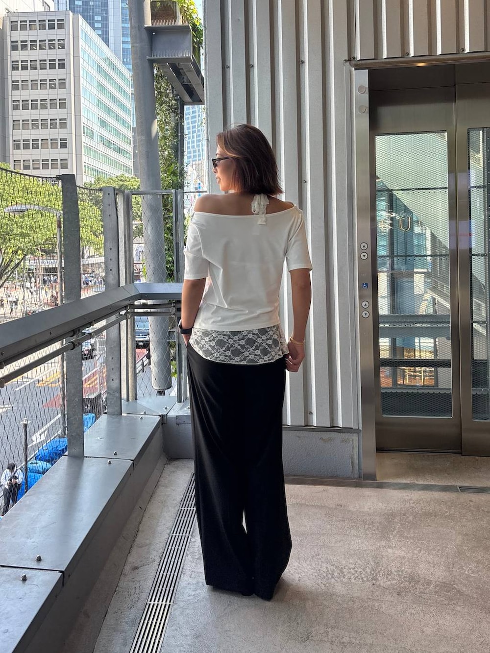 ブラック系のその他パンツ、ブラック系のサンダル、ホワイト系のTシャツ/カットソーを着用したレディースの春コーディネートの4枚目の写真