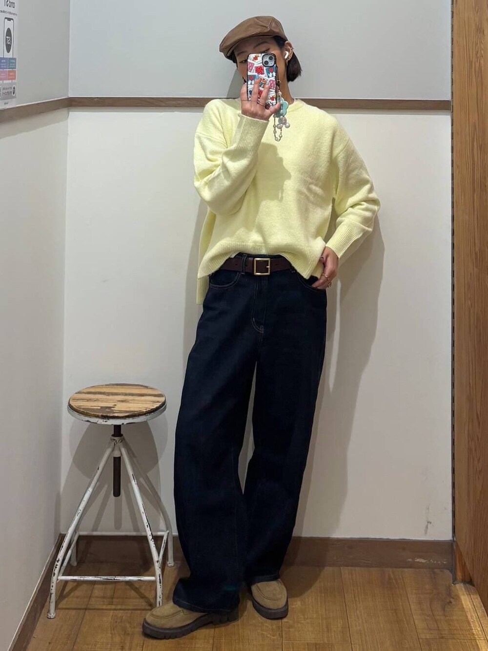 ブルー系のデニムパンツ、ベージュ系のローファー、イエロー系のニット/セーターを着用したレディースの冬コーディネートの3枚目の写真