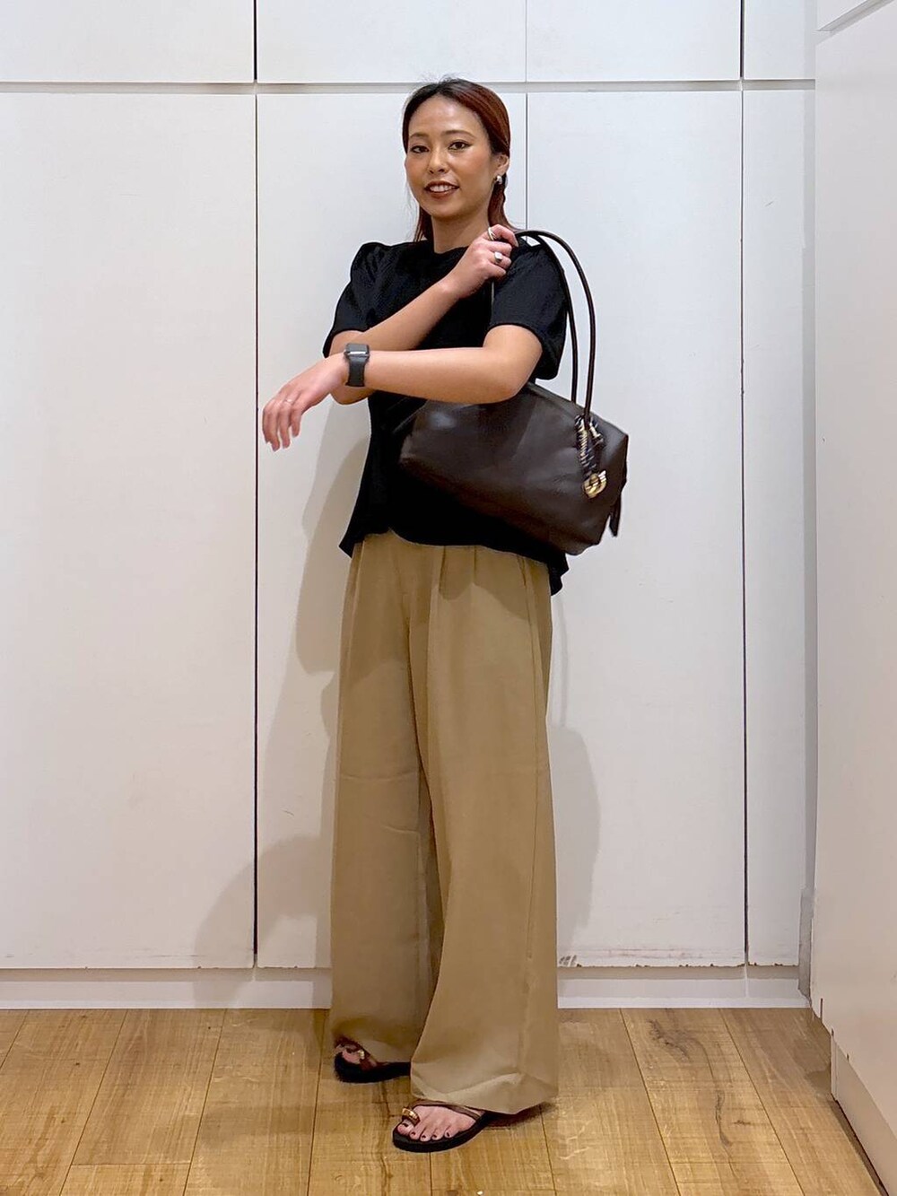 ベージュ系のその他パンツ、ブラック系のTシャツ/カットソー、ブラウン系のサンダルを着用したレディースの夏コーディネートの2枚目の写真