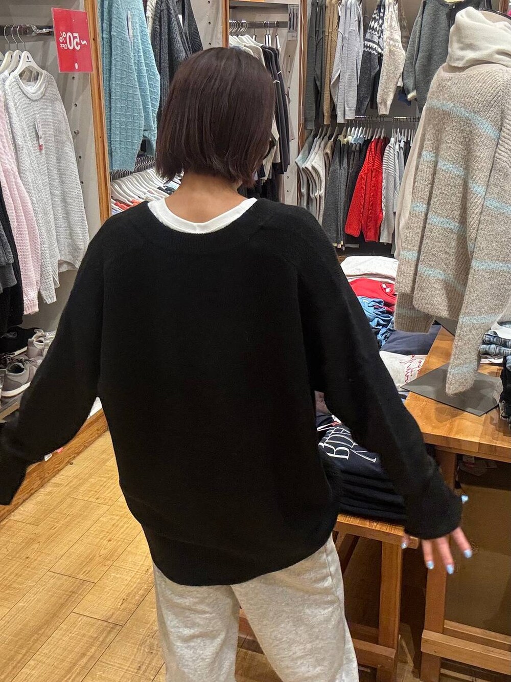 ブラック系のボストンバッグ、ブラック系のニット/セーター、ホワイト系のTシャツ/カットソーを着用したレディースの冬コーディネートの5枚目の写真