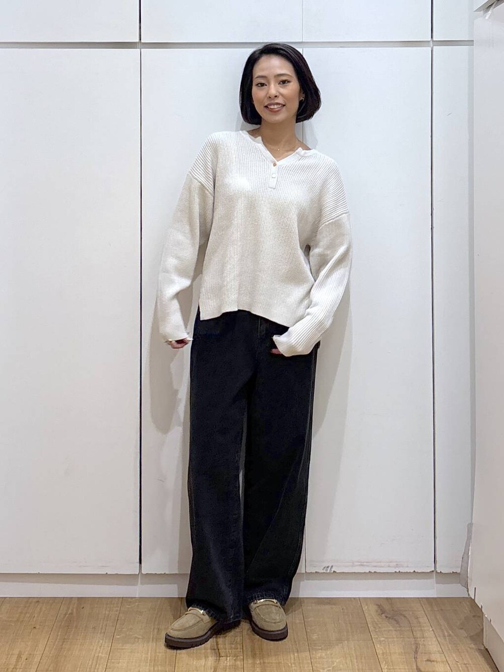 ブラック系のデニムパンツ、ベージュ系のローファー、ベージュ系のニット/セーターを着用したレディースの秋コーディネートの4枚目の写真