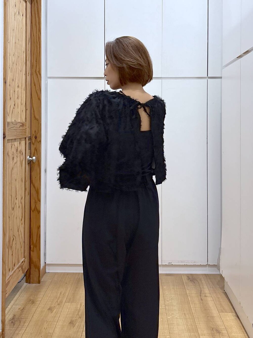 ブラック系のブーツ、ブラック系のシャツ/ブラウス、ブラック系のスラックスを着用したレディースの秋コーディネートの6枚目の写真