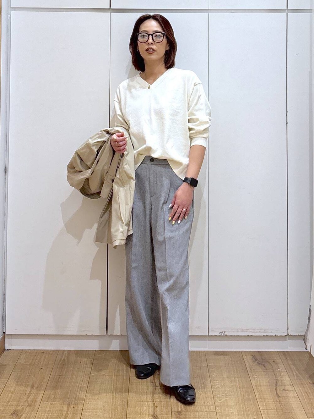 ブラック系のローファー、グレー系のその他パンツ、ベージュ系のステンカラーコートを着用したレディースの春コーディネートの2枚目の写真