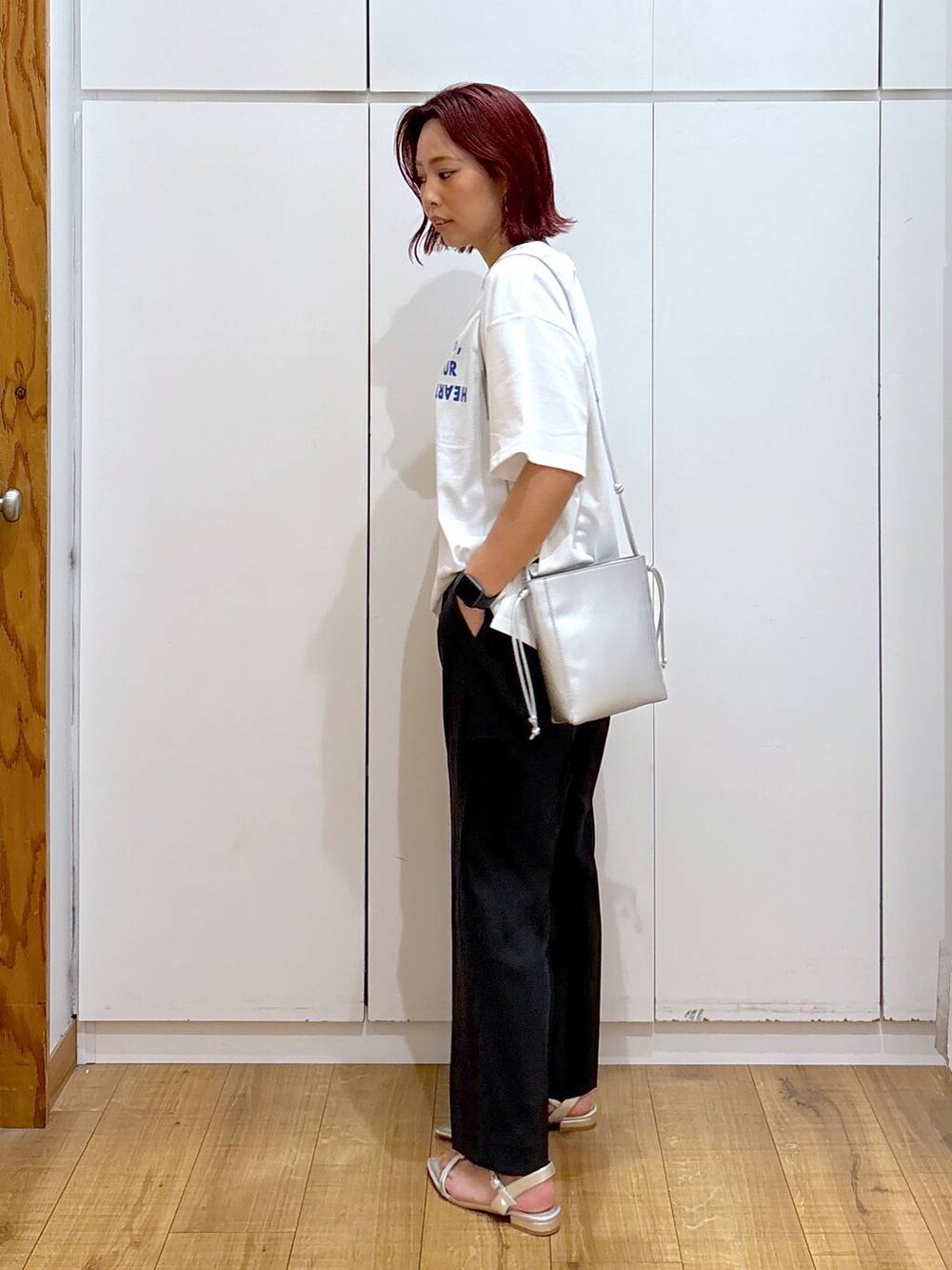 ホワイト系のTシャツ/カットソー、ブラック系のその他パンツ、シルバー系のショルダーバッグを着用したレディースの春コーディネートの4枚目の写真