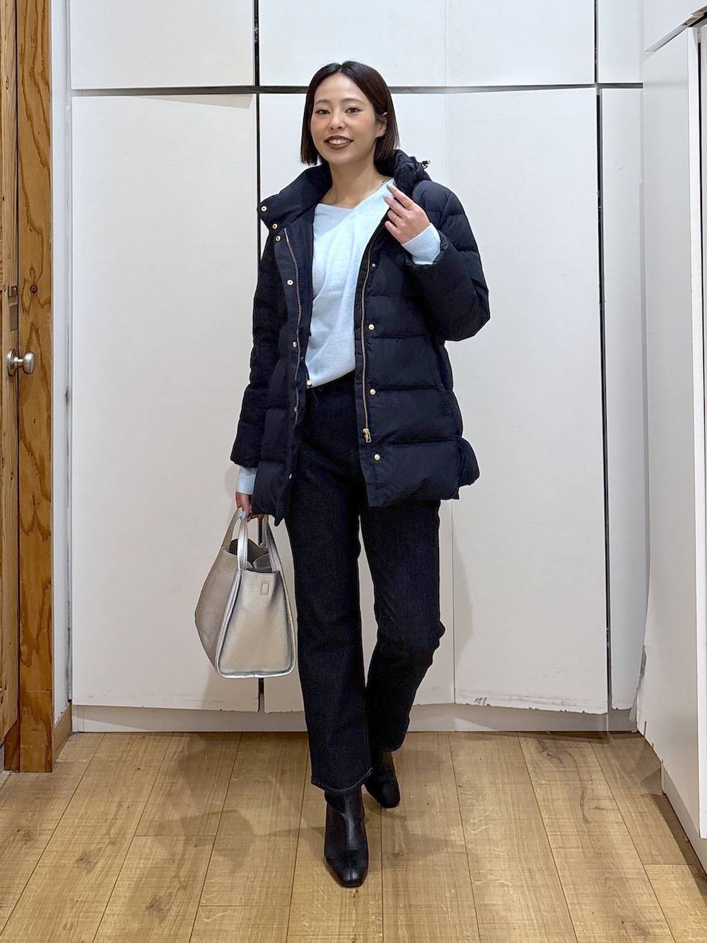 ブルー系のダウンジャケット/コート、ブルー系のデニムパンツ、シルバー系のトートバッグを着用したレディースの冬コーディネートの3枚目の写真