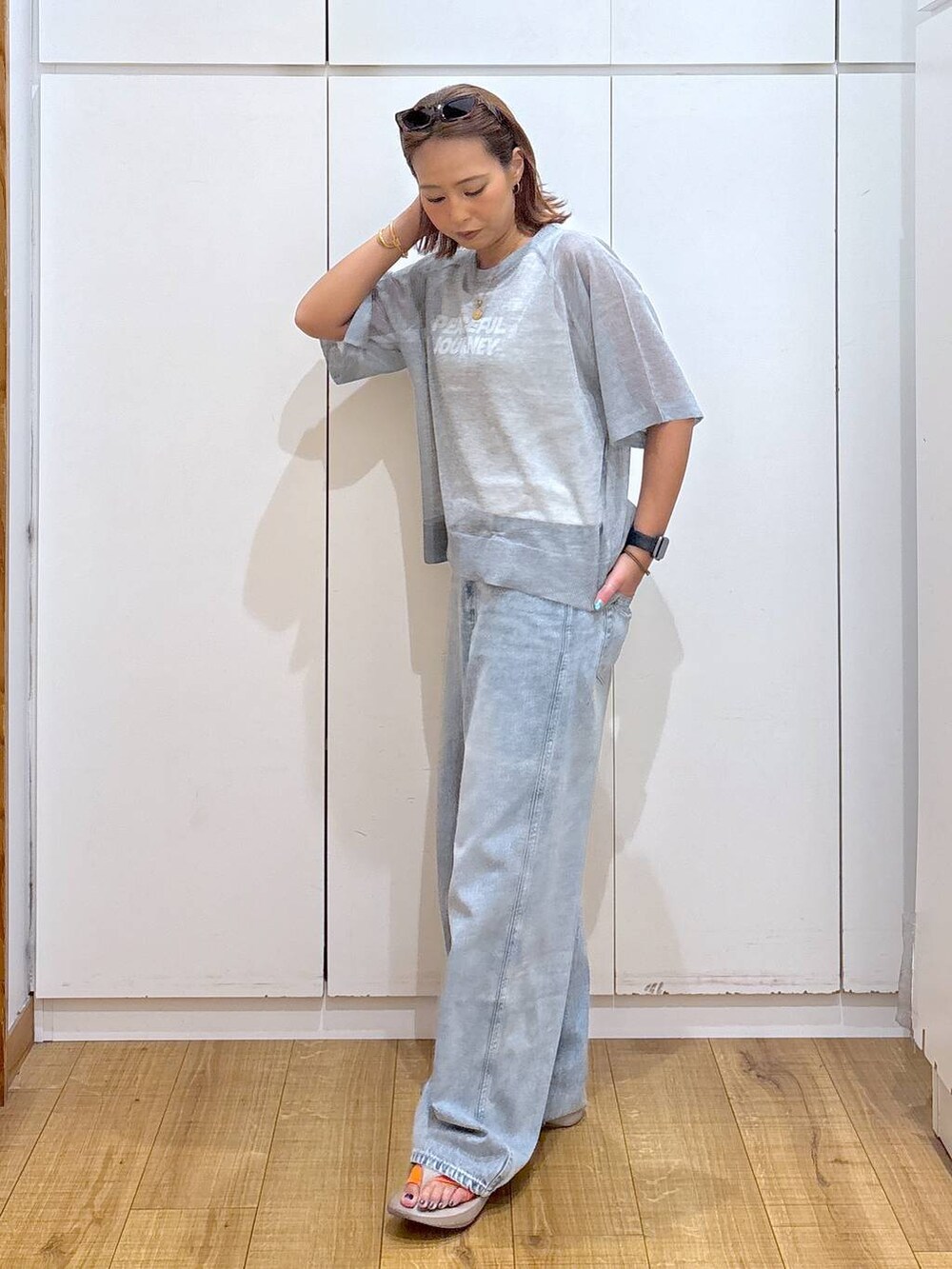 ブルー系のデニムパンツ、ホワイト系のタンクトップ、ベージュ系のサンダルを着用したレディースの夏コーディネートの3枚目の写真