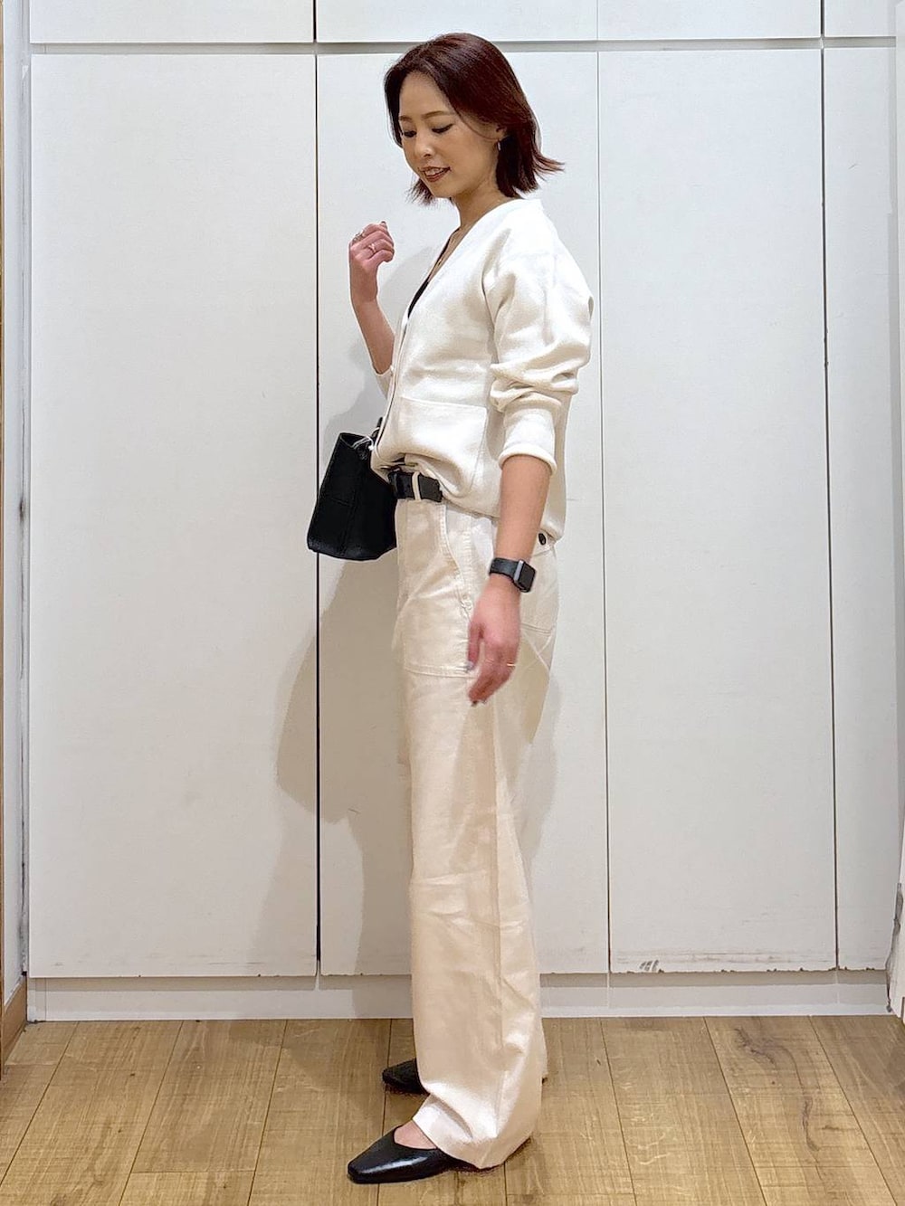 ブラック系のパンプス、ベージュ系のカーディガン/ボレロ、ブラック系のショルダーバッグを着用したレディースの春コーディネートの4枚目の写真