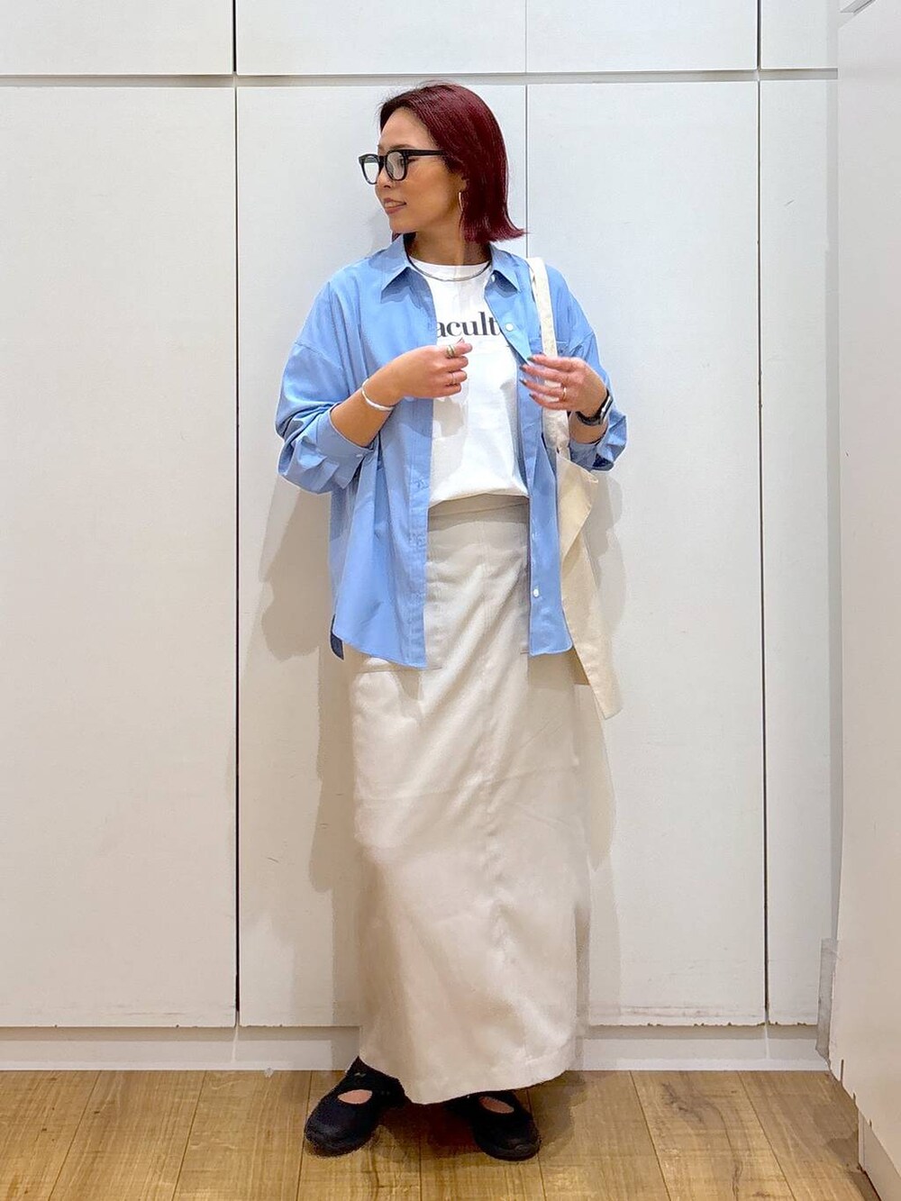 ブラック系のスニーカー、ホワイト系のTシャツ/カットソー、ブルー系のシャツ/ブラウスを着用したレディースの春コーディネートの4枚目の写真