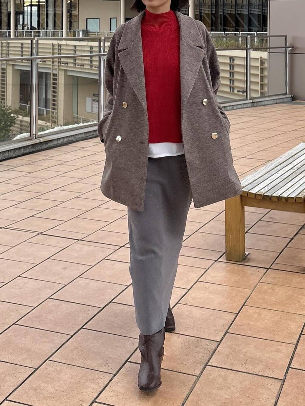 ブラウン系のチェスターコート、グレー系のスカート、ホワイト系のTシャツ/カットソーを着用したレディースの秋コーディネートの3枚目の写真