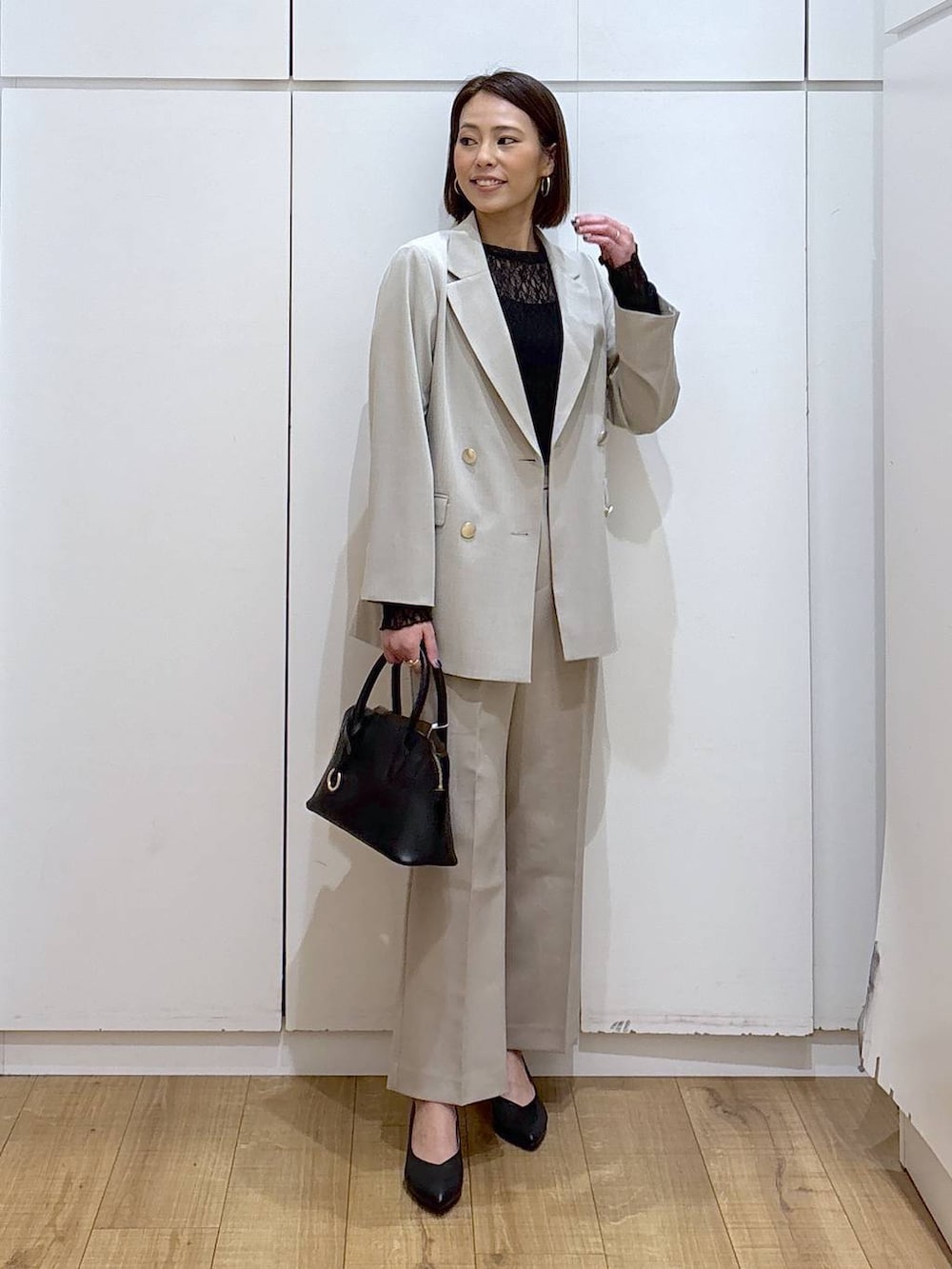 ブラック系のショルダーバッグ、ブラック系のパンプス、ブラック系のTシャツ/カットソーを着用したレディースの冬コーディネートの3枚目の写真