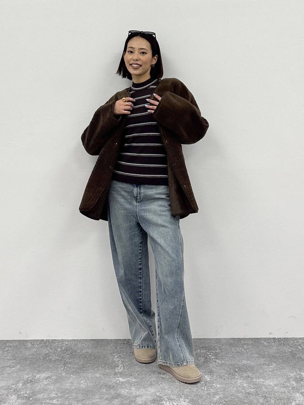 ホワイト系のニット/セーター、ブルー系のデニムパンツ、ブラウン系のノーカラージャケットを着用したレディースの冬コーディネートの3枚目の写真