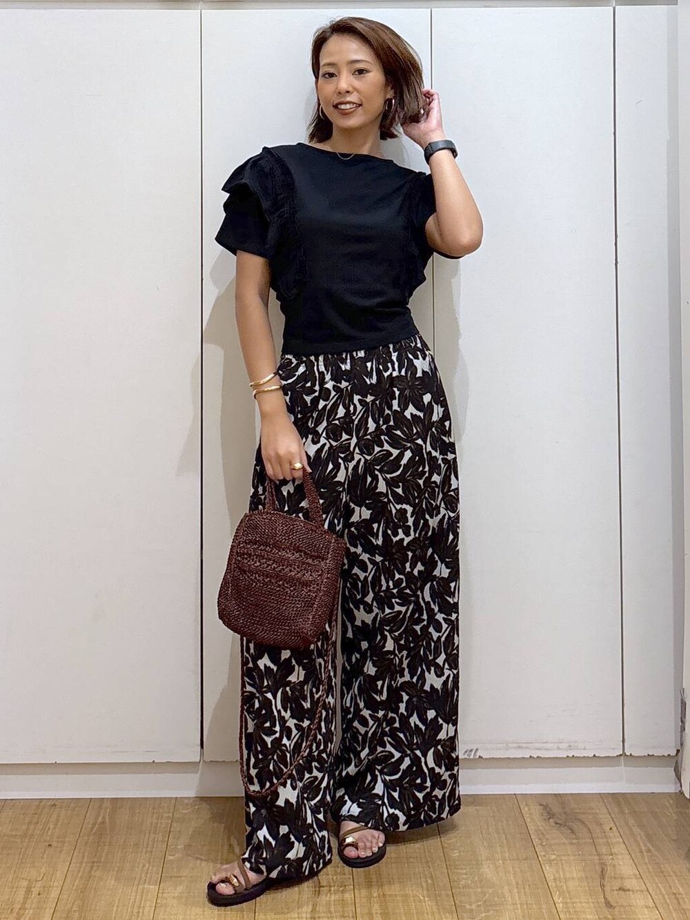 ベージュ系のその他パンツ、ブラウン系のクラッチバッグ、ブラック系のTシャツ/カットソーを着用したレディースの夏コーディネートの2枚目の写真
