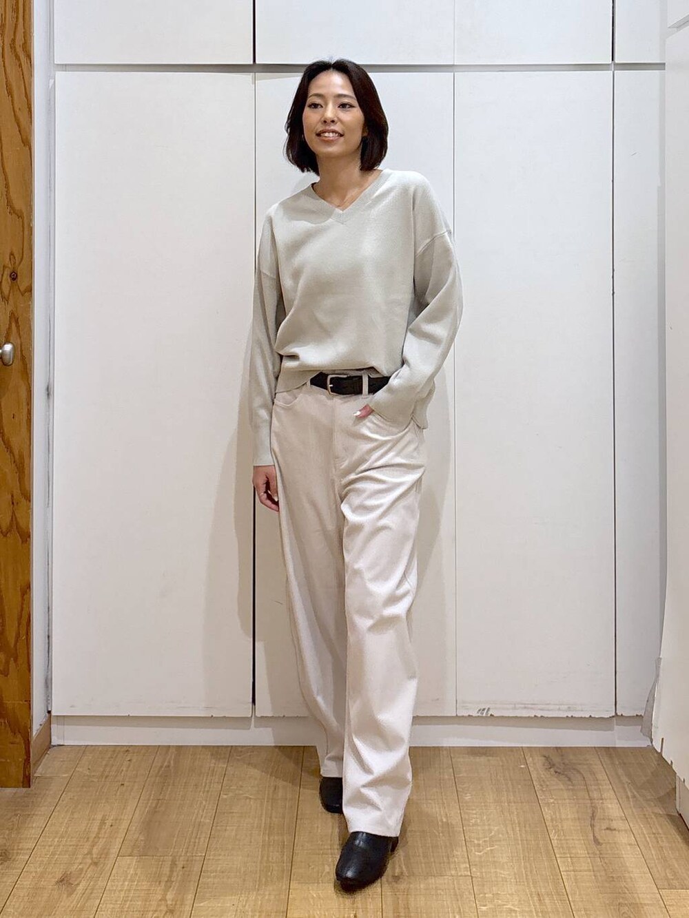 ブルー系のチェスターコート、ベージュ系のスウェット、グレー系のその他パンツを着用したレディースの秋コーディネートの4枚目の写真