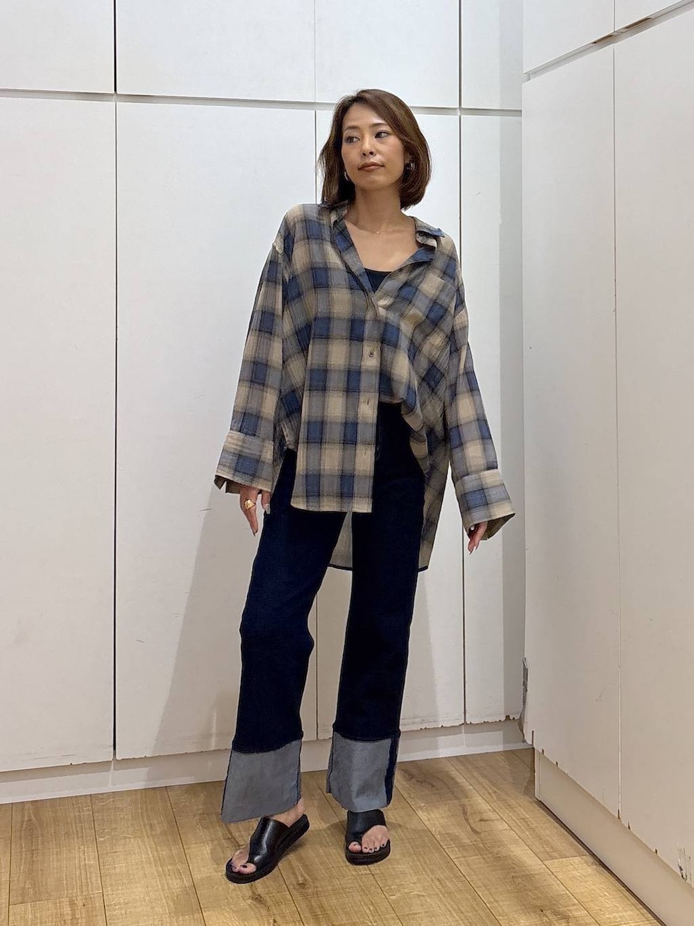 ブルー系のデニムパンツ、ブラック系のキャミソール、ベージュ系のシャツ/ブラウスを着用したレディースの夏コーディネートの4枚目の写真