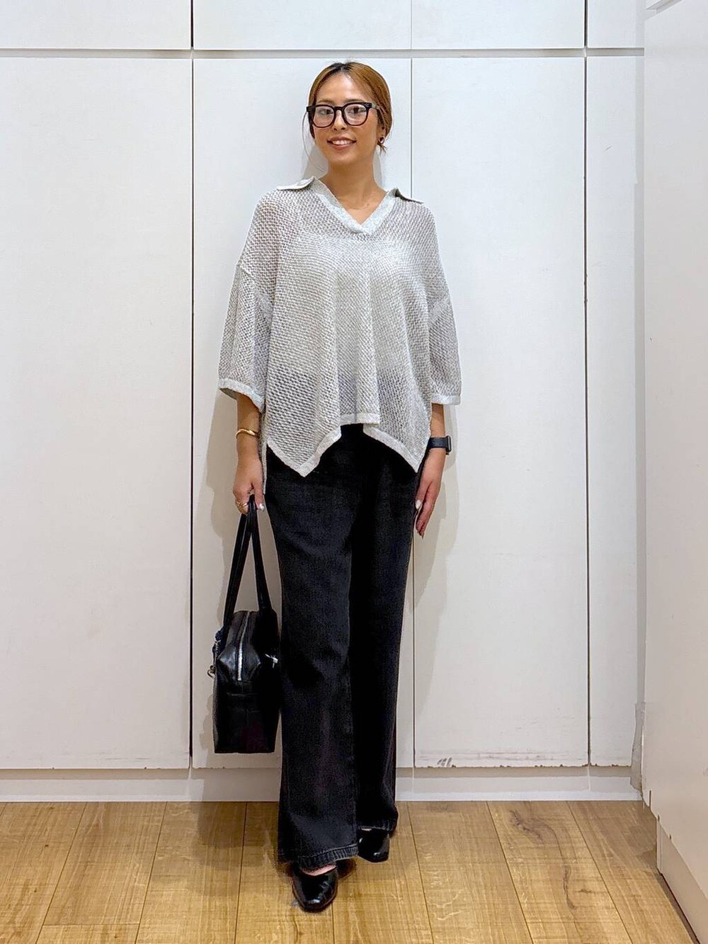 ブラック系のパンプス、ホワイト系のキャミソール、ブラック系のボストンバッグを着用したレディースの秋コーディネートの2枚目の写真