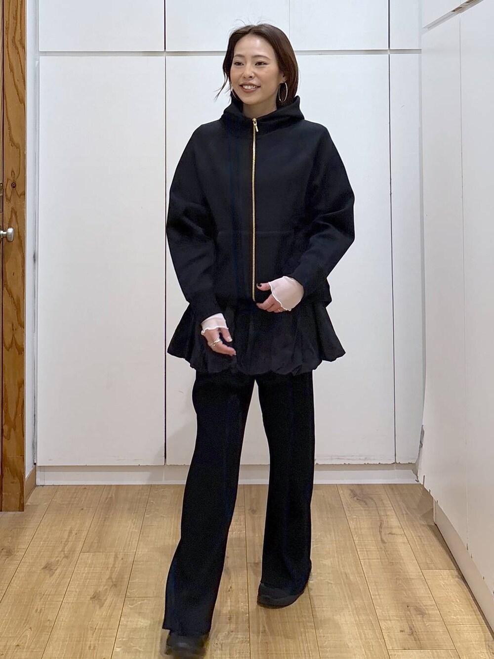 ブラック系のパーカー、ホワイト系のTシャツ/カットソー、ブラック系のその他パンツを着用したレディースの春コーディネートの6枚目の写真