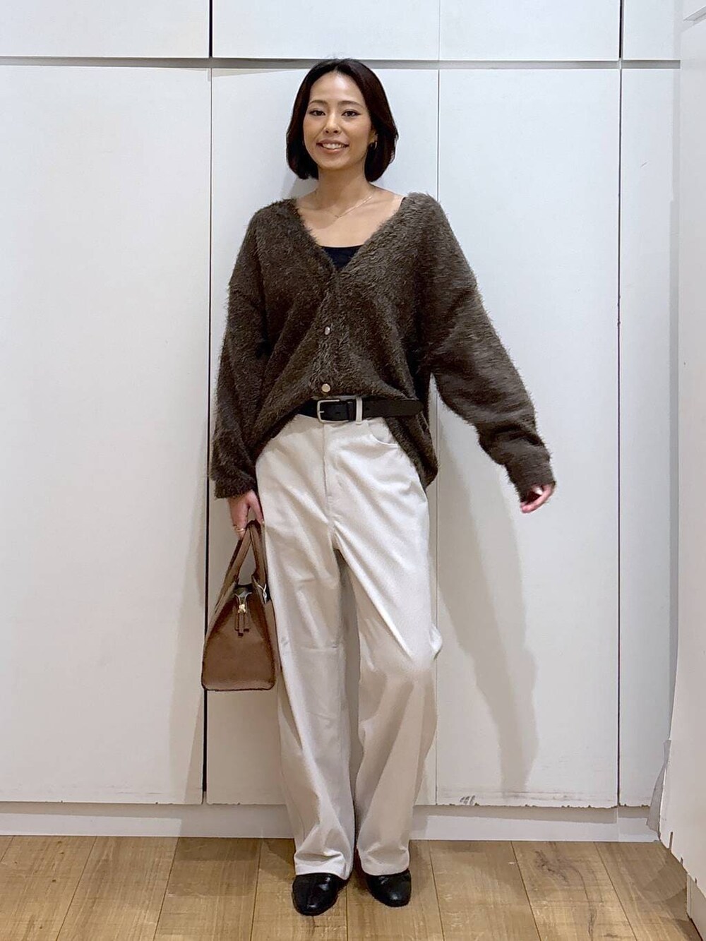 グレー系のその他パンツ、ベージュ系のショルダーバッグ、ブラウン系のカーディガン/ボレロを着用したレディースの秋コーディネートの5枚目の写真