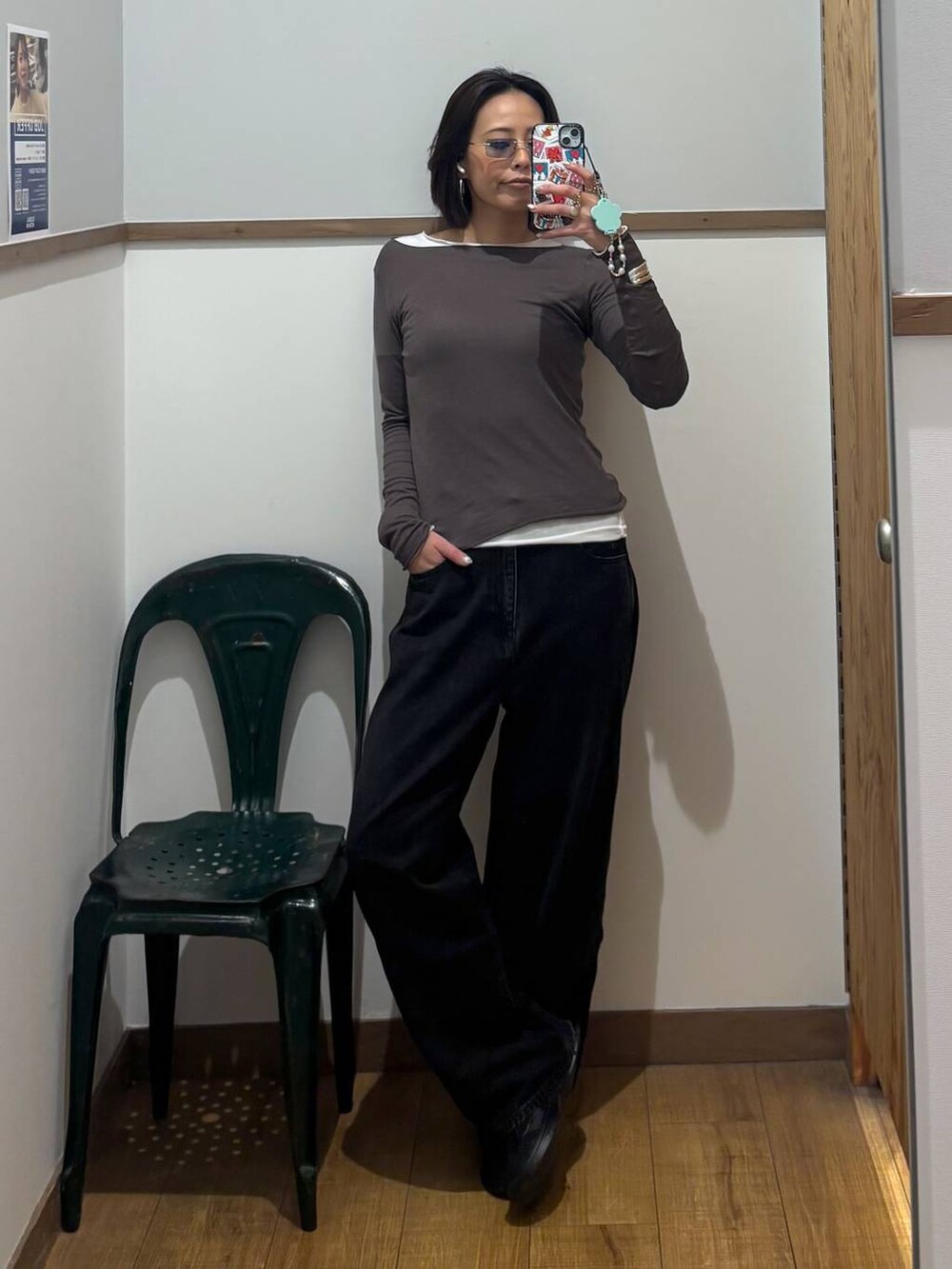 ブラック系のデニムパンツ、ブラック系のスニーカー、ホワイト系のTシャツ/カットソーを着用したレディースの秋コーディネートの2枚目の写真