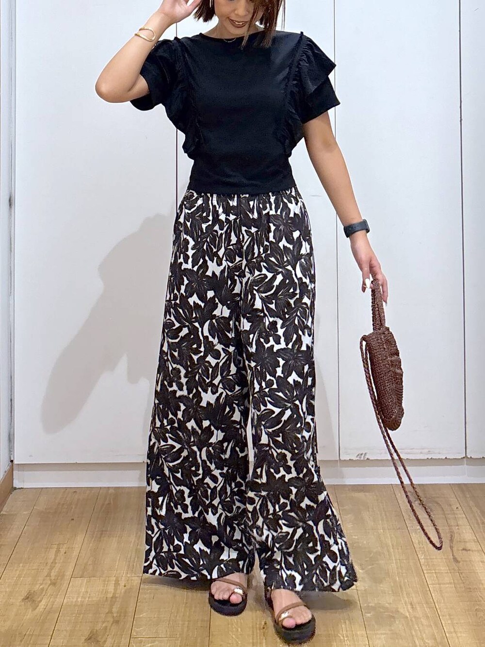 ベージュ系のその他パンツ、ブラウン系のクラッチバッグ、ブラック系のTシャツ/カットソーを着用したレディースの夏コーディネートの4枚目の写真