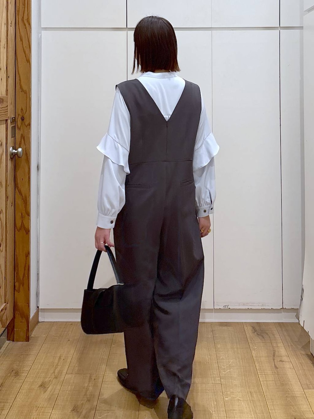 ブラック系のローファー、グレー系のセットアップ、ブラック系のハンドバッグを着用したレディースの冬コーディネートの6枚目の写真