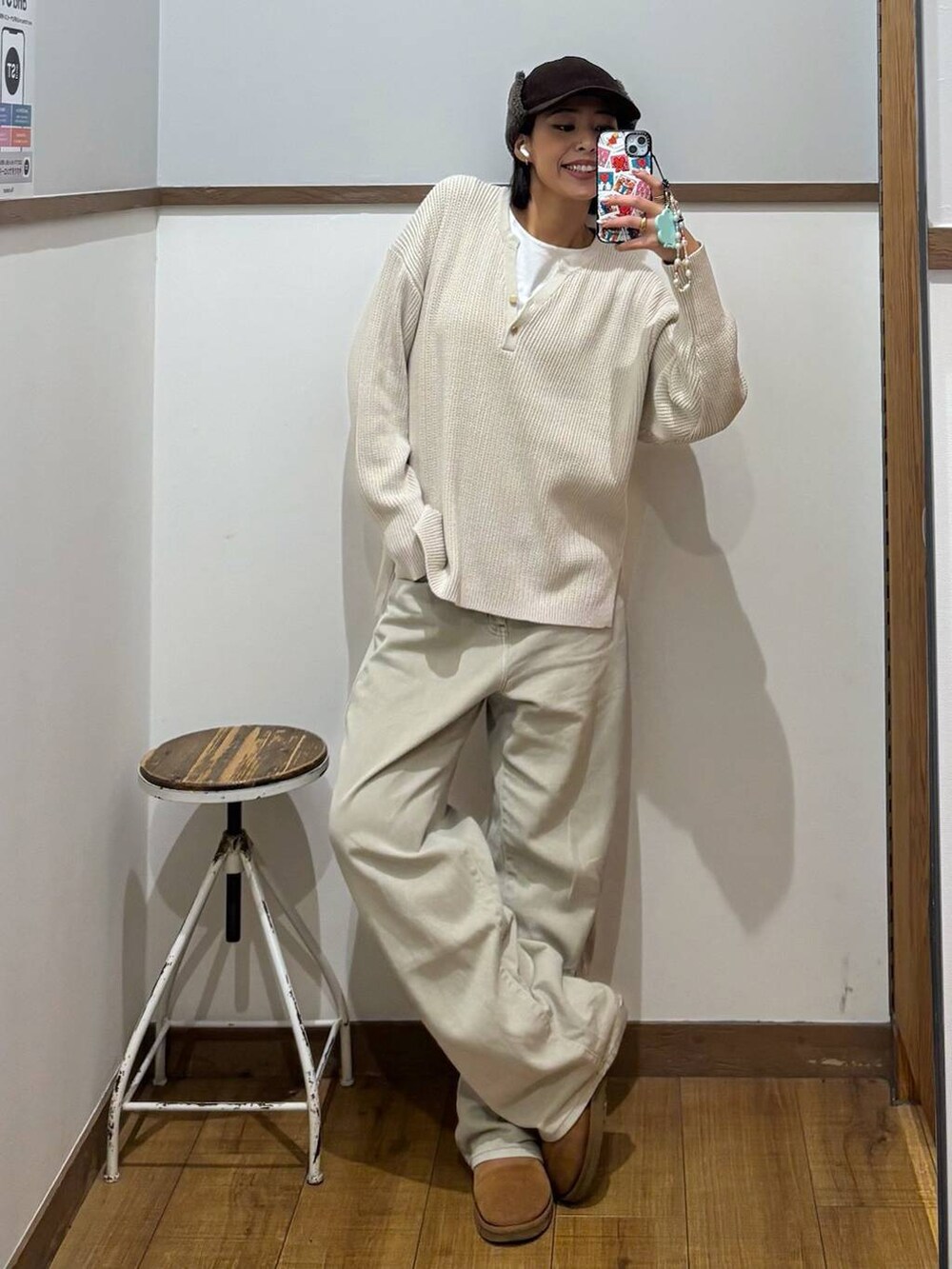 ベージュ系のデニムパンツ、ホワイト系のTシャツ/カットソー、ベージュ系のニット/セーターを着用したレディースの秋コーディネートの2枚目の写真