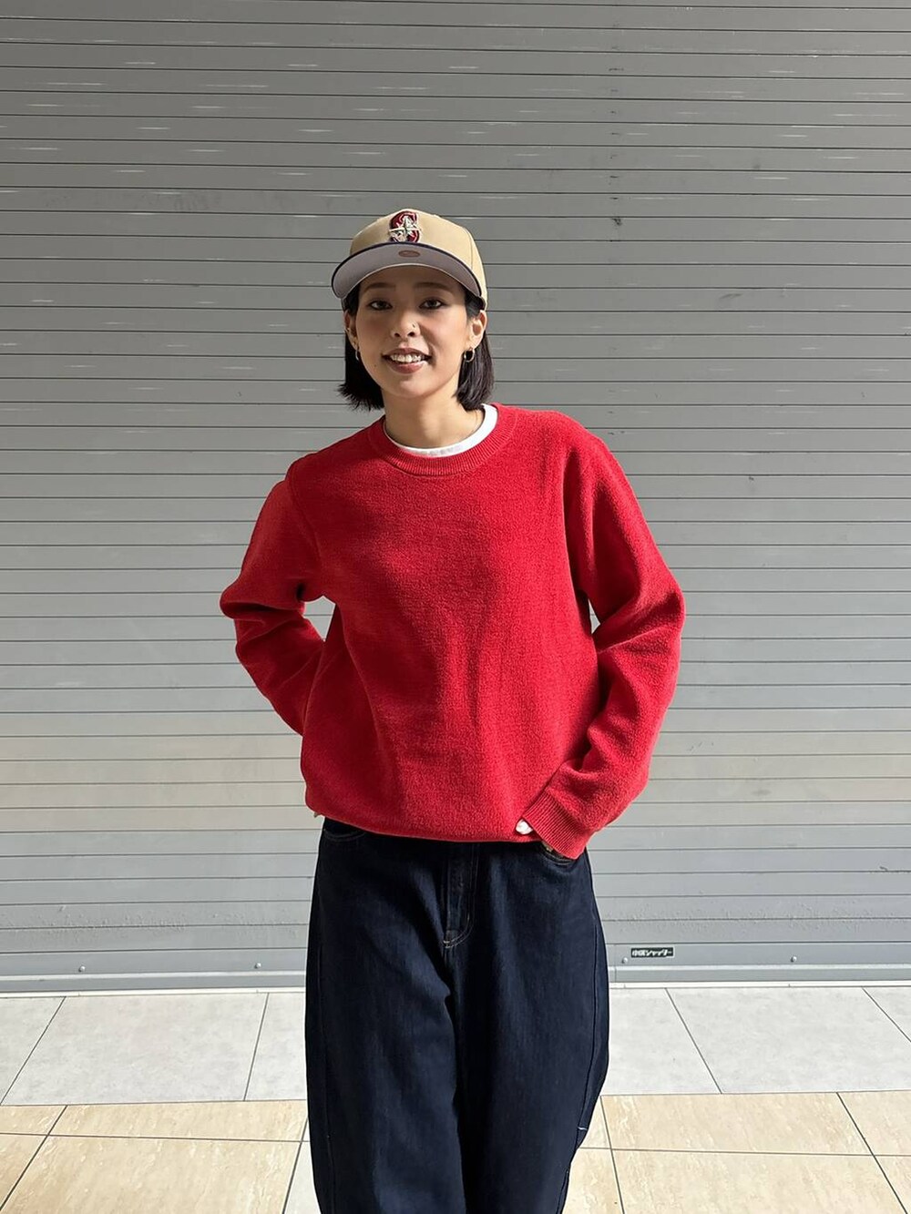 ブルー系のデニムパンツ、レッド系のニット/セーターを着用したレディースの秋コーディネートの2枚目の写真