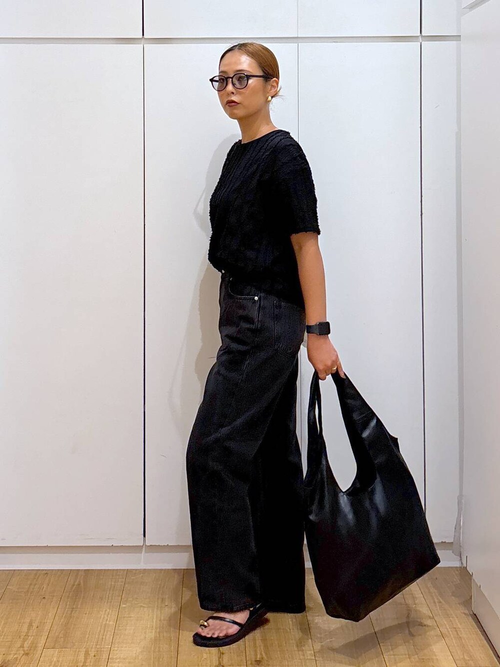 ブラック系のTシャツ/カットソー、ブラック系のトートバッグ、ブラック系のサンダルを着用したレディースの夏コーディネートの3枚目の写真