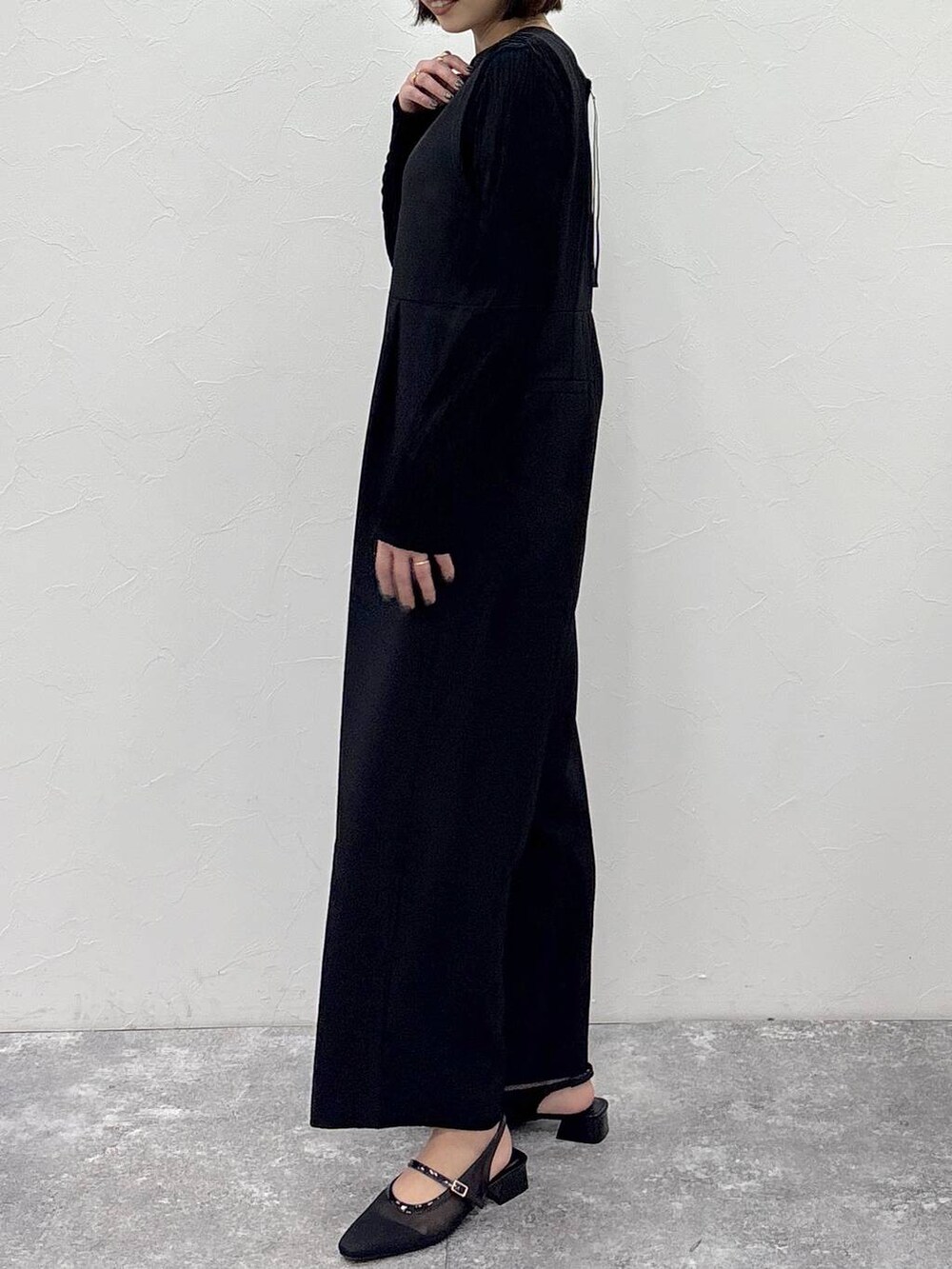 ブラック系のTシャツ/カットソー、ブラック系のサロペット/オーバーオール、ゴールド系のピアス（両耳用）を着用したレディースの冬コーディネートの5枚目の写真