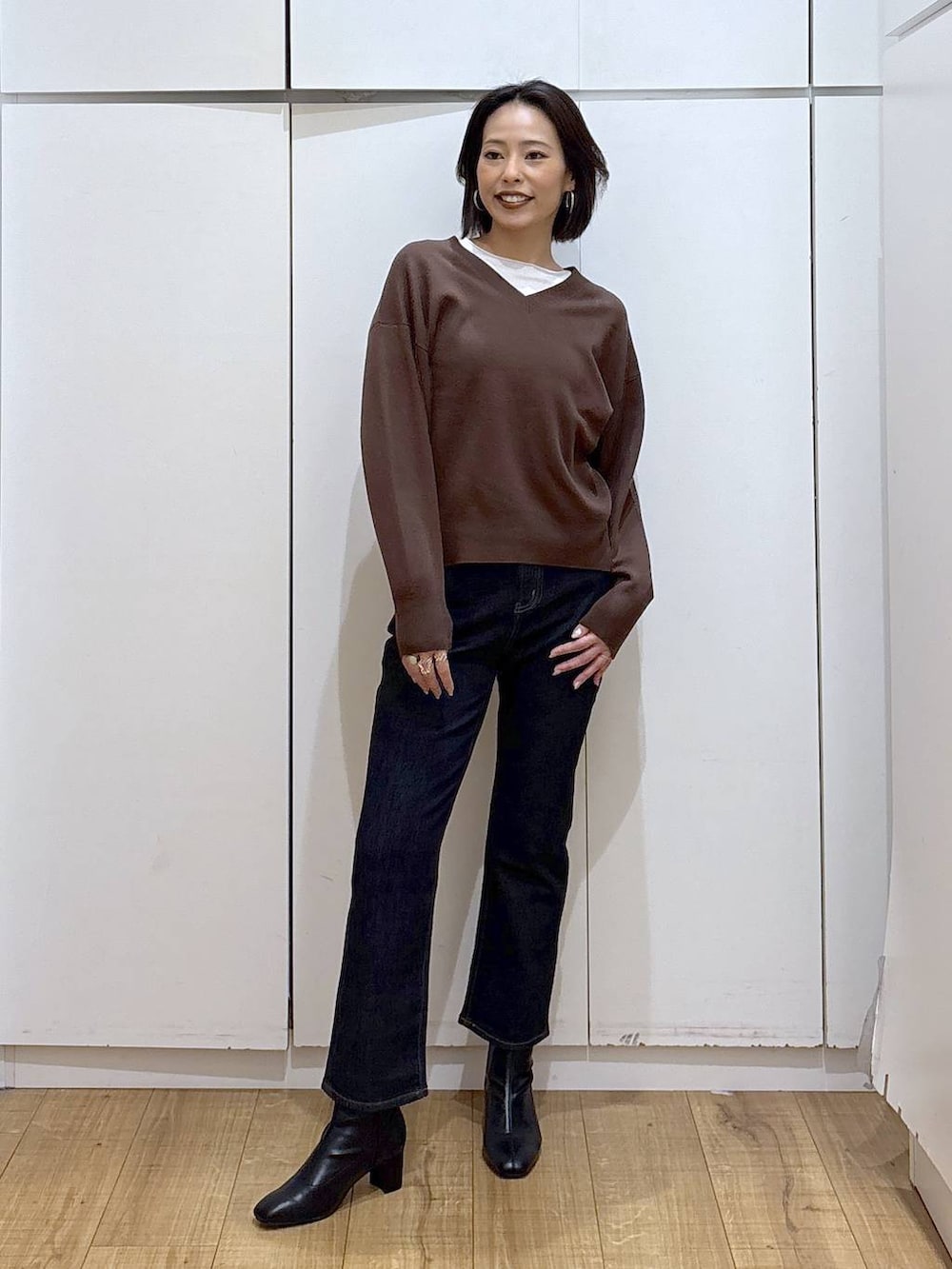 ブルー系のデニムパンツ、ブラウン系のスウェット、ブラック系のブーツを着用したレディースの秋コーディネートの4枚目の写真