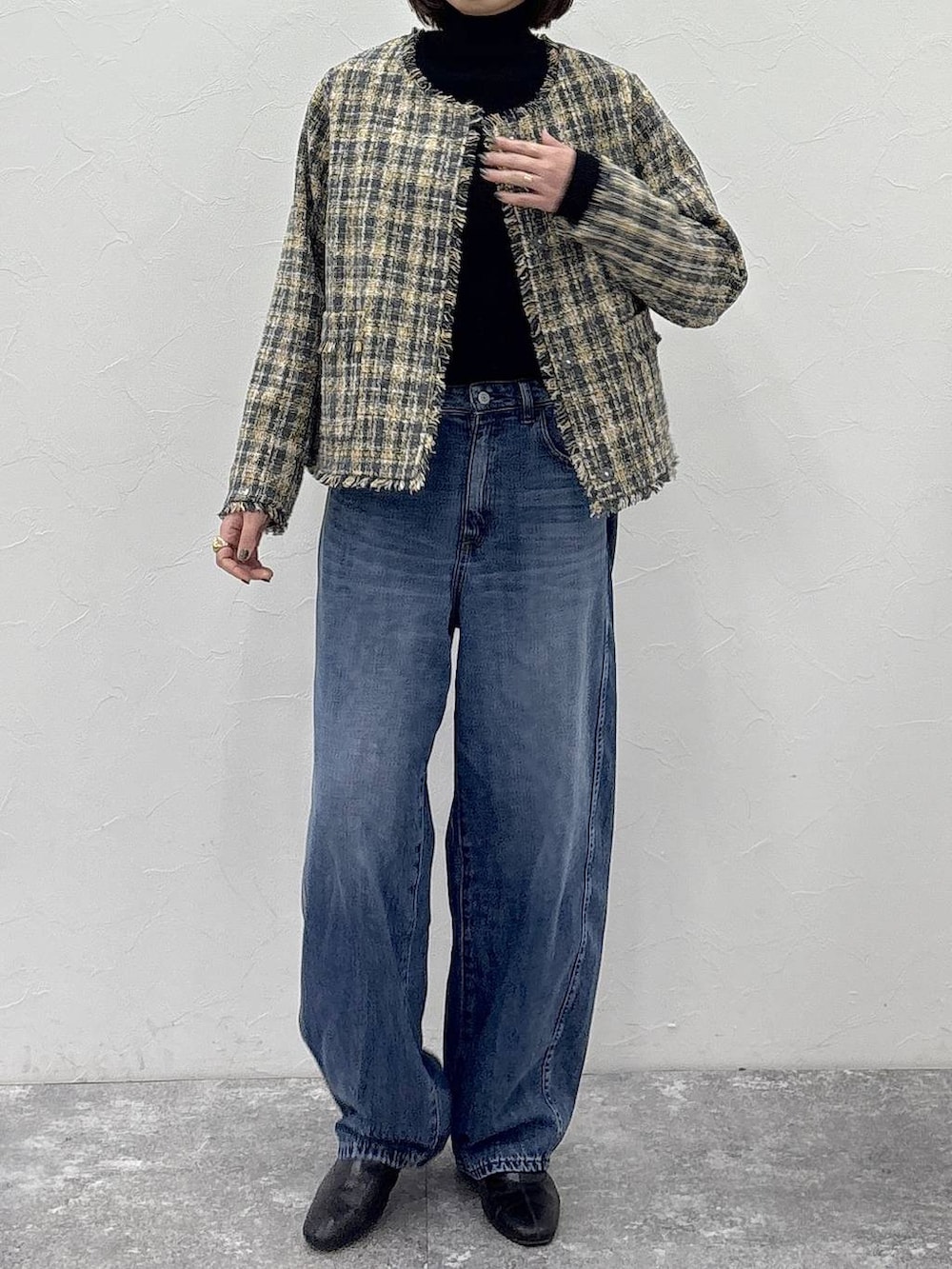 ブラック系のニット/セーター、ブラック系のブーツ、ブルー系のデニムパンツを着用したレディースの冬コーディネートの6枚目の写真