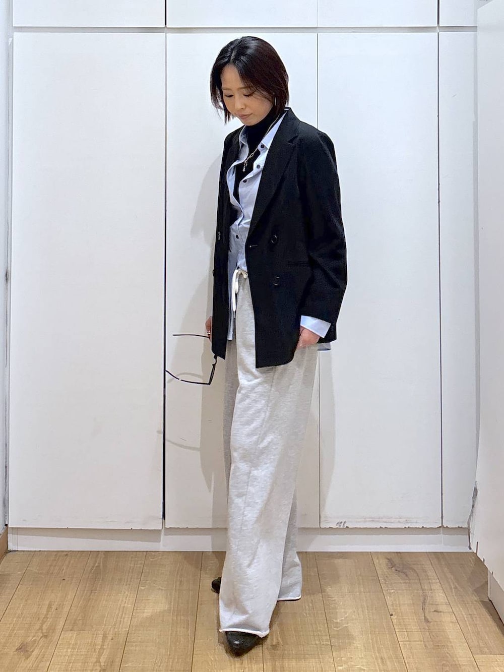 ブラック系のローファー、ブラック系のニット/セーター、ブルー系のシャツ/ブラウスを着用したレディースの冬コーディネートの3枚目の写真