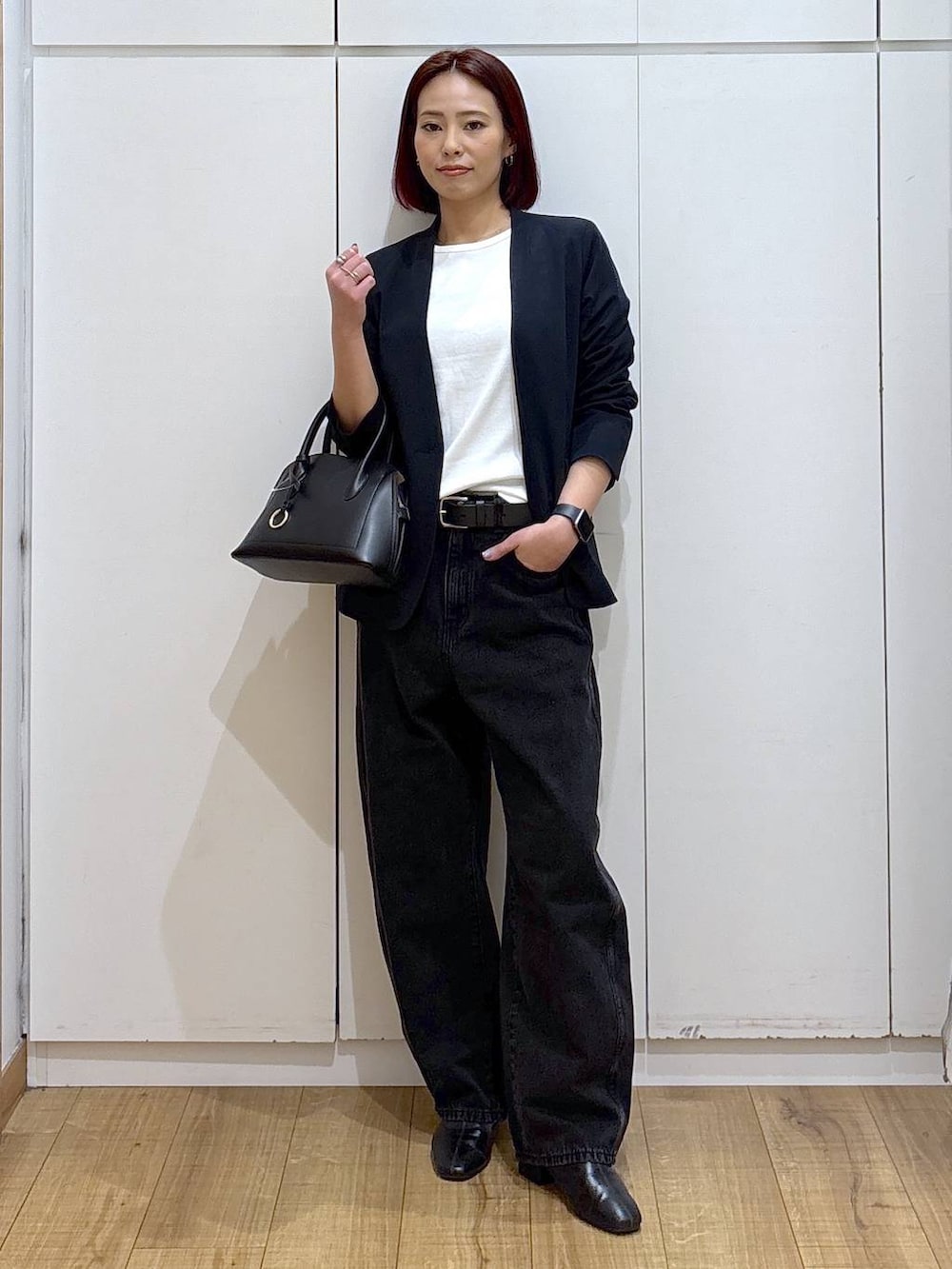 ブラック系のショルダーバッグ、ブラック系のブーツ、ブルー系のノーカラージャケットを着用したレディースの春コーディネートの2枚目の写真