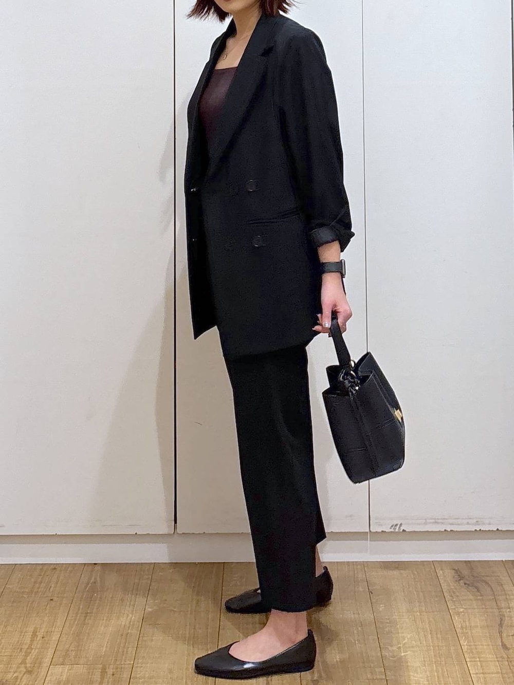 ブラック系のパンプス、ブラック系のスラックス、ブラック系のテーラードジャケットを着用したレディースの春コーディネートの4枚目の写真