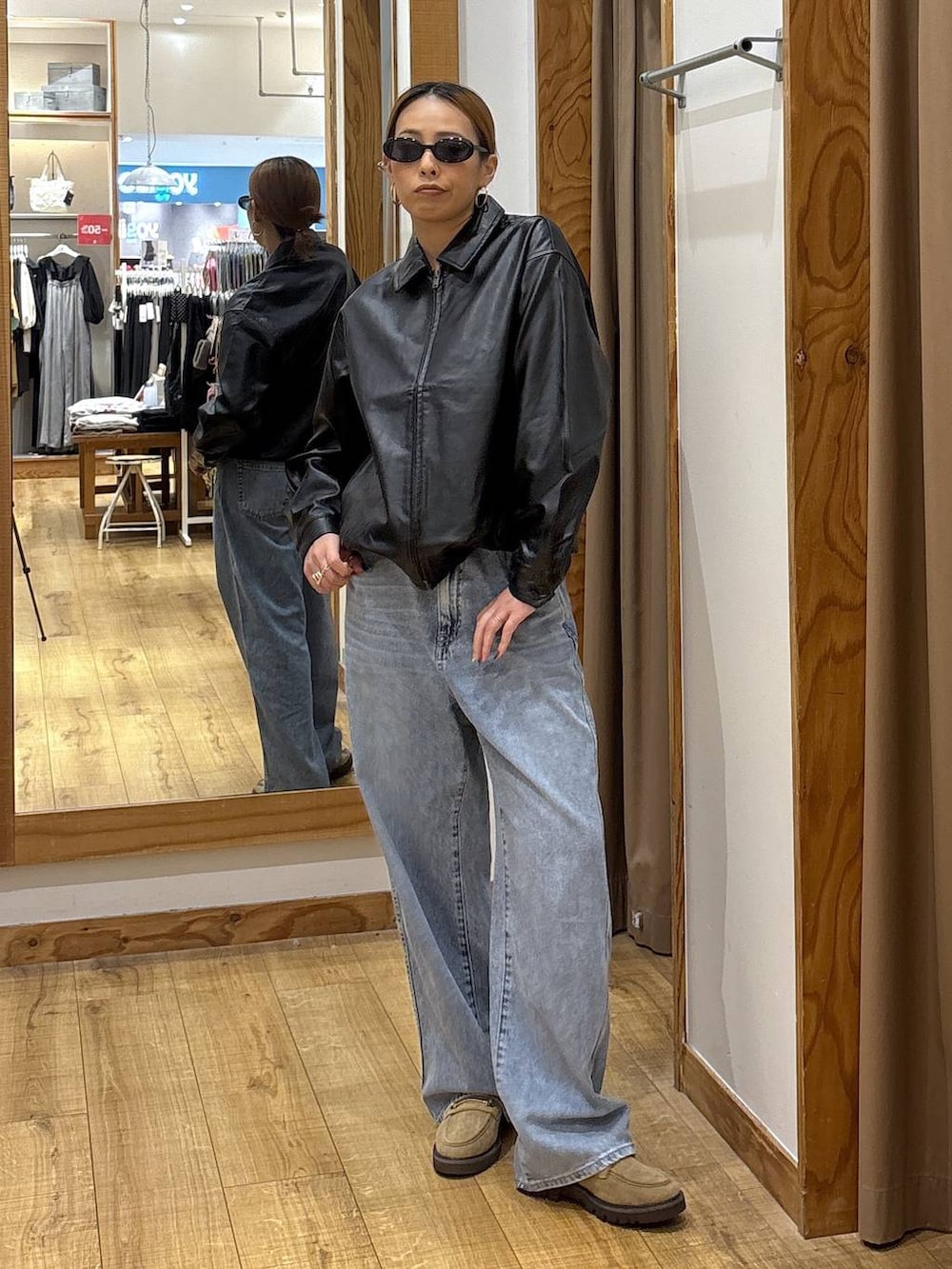 ブラック系のブルゾン、ブルー系のデニムパンツ、ベージュ系のローファーを着用したレディースの秋コーディネートの3枚目の写真