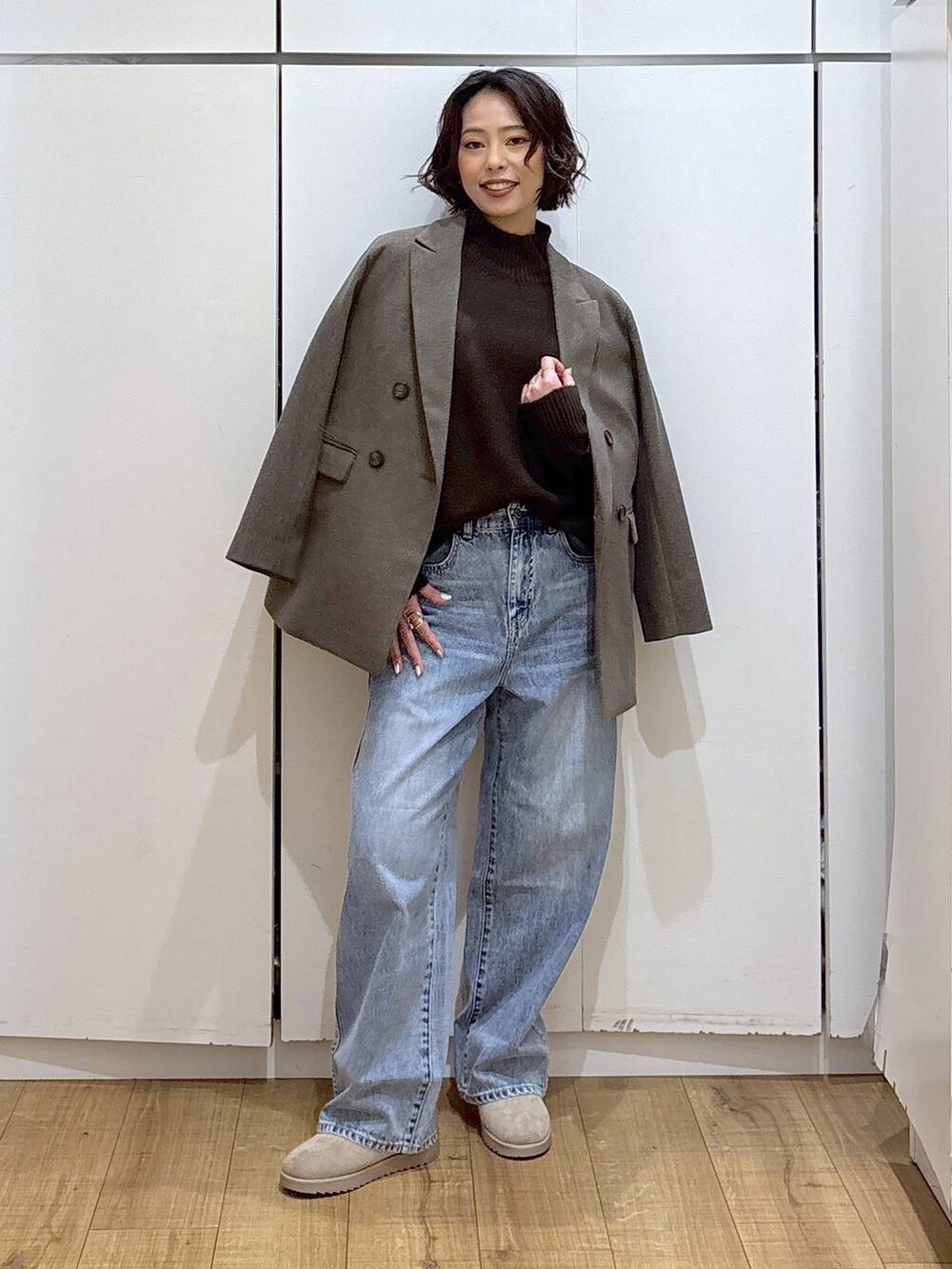 ブルー系のデニムパンツ、ブラウン系のニット/セーター、ブラウン系のテーラードジャケットを着用したレディースの冬コーディネートの2枚目の写真