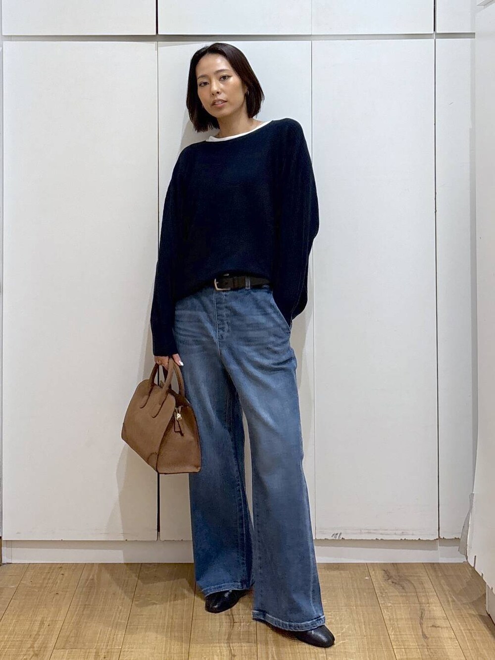 ベージュ系のショルダーバッグ、ブルー系のニット/セーター、ブラック系のブーツを着用したレディースの秋コーディネートの2枚目の写真