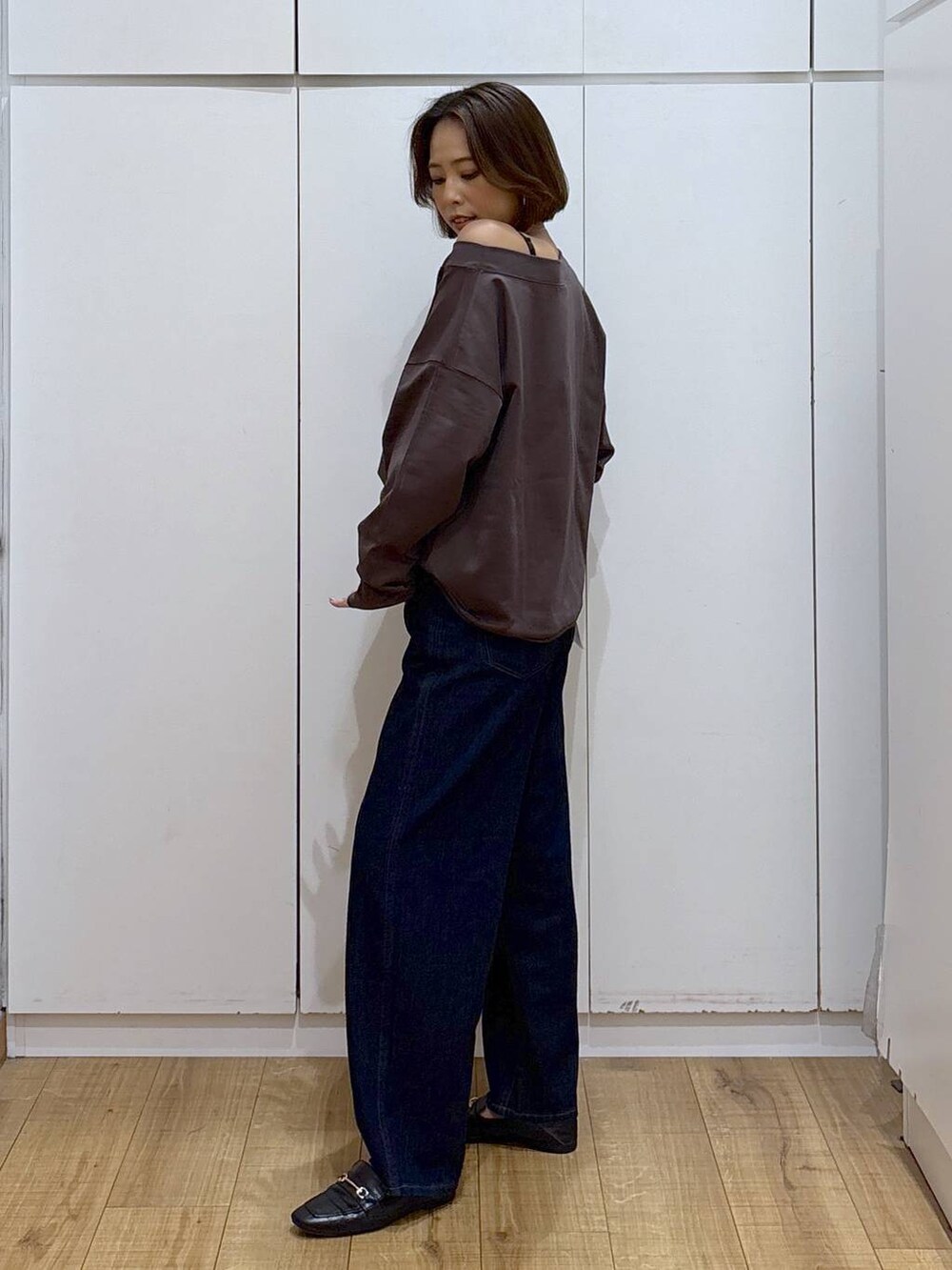 ブラック系のローファー、ブルー系のデニムパンツ、ブラウン系のスウェットを着用したレディースの秋コーディネートの3枚目の写真