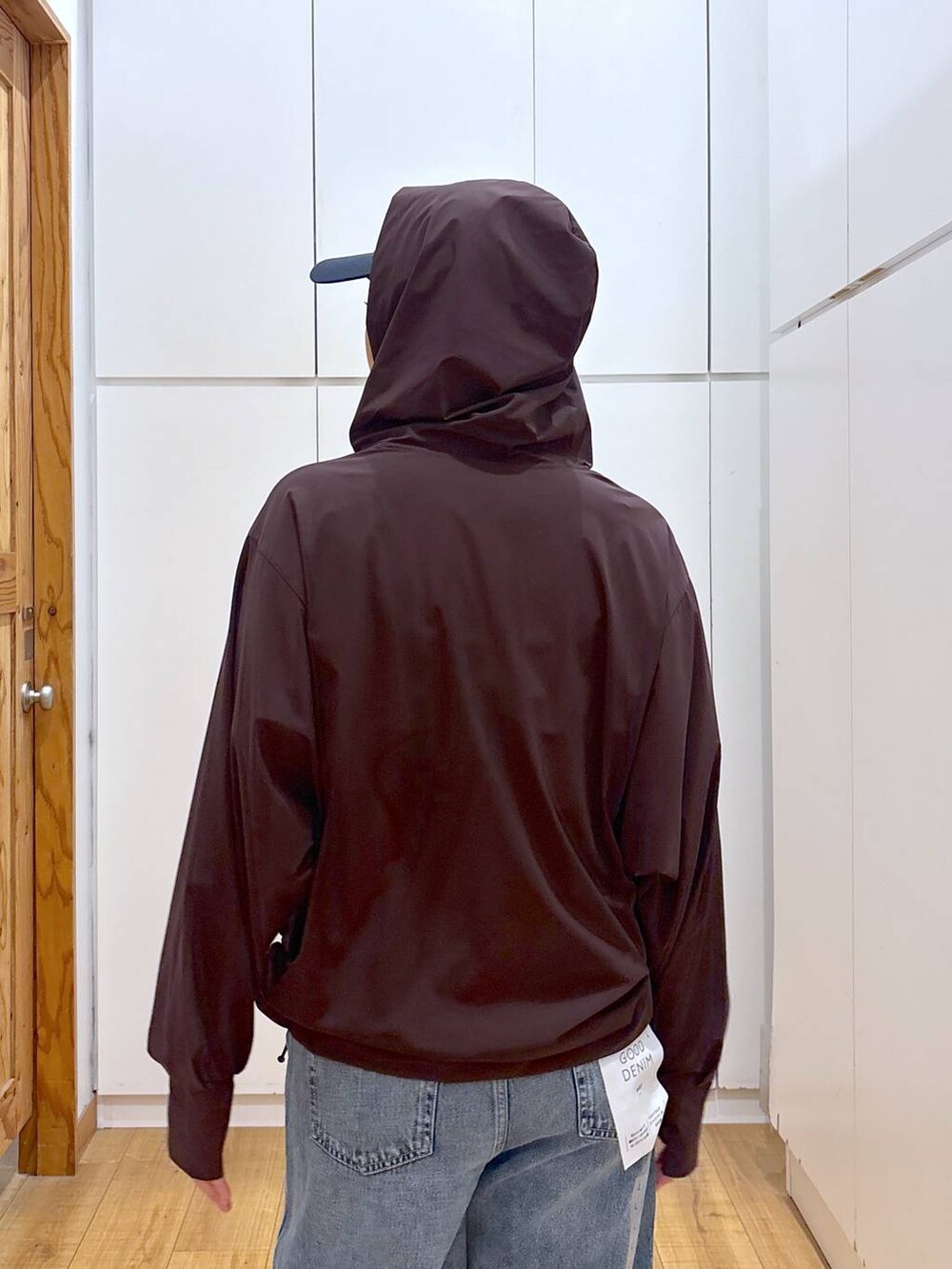 ブルー系のデニムパンツ、ブラウン系のマウンテンパーカー、ブルー系のキャップを着用したレディースの夏コーディネートの5枚目の写真