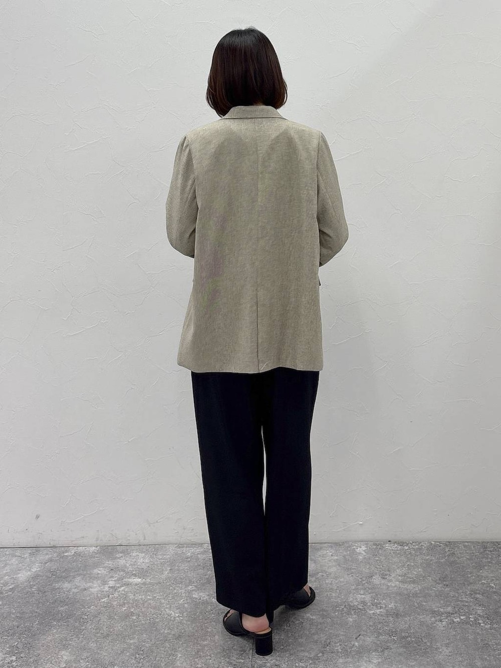 ブラウン系のショルダーバッグ、ベージュ系のテーラードジャケット、ブラック系のサロペット/オーバーオールを着用したレディースの冬コーディネートの4枚目の写真