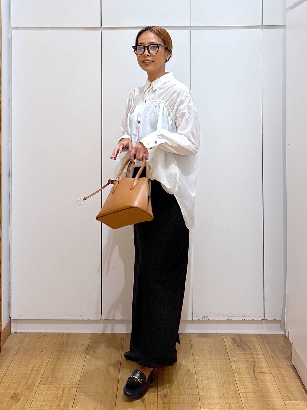 ブラック系のローファー、ブラウン系のショルダーバッグ、ブラック系のキャミソールを着用したレディースの秋コーディネートの2枚目の写真