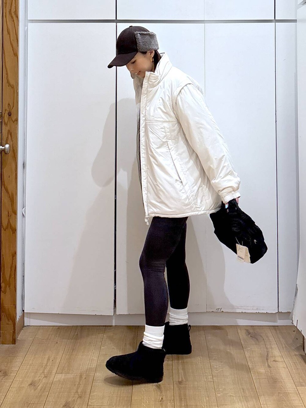 ブラック系のショルダーバッグ、ベージュ系のブルゾン、ホワイト系のTシャツ/カットソーを着用したレディースの冬コーディネートの3枚目の写真