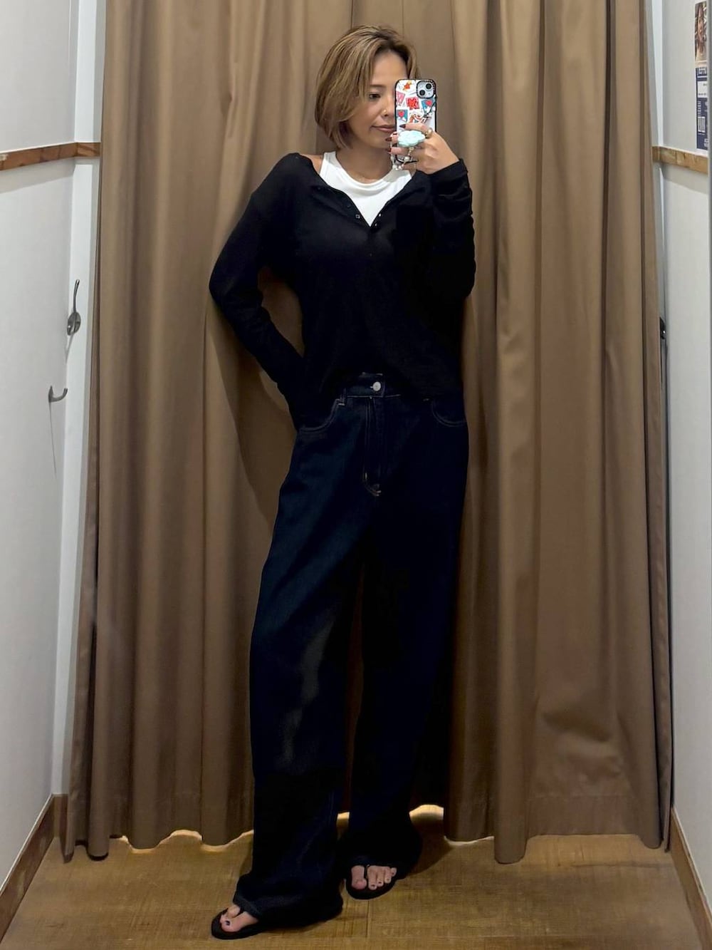 ブラック系のTシャツ/カットソー、ブルー系のデニムパンツを着用したレディースの秋コーディネートの5枚目の写真