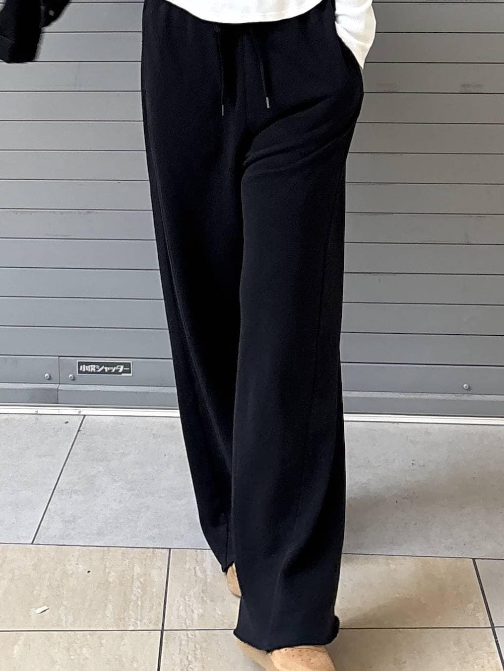 ブラック系のデニムジャケット、ブラック系のスウェットパンツ、ゴールド系のネックレスを着用したレディースの春コーディネートの7枚目の写真