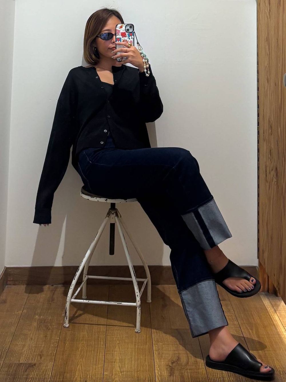 ブルー系のデニムパンツ、ブラック系のキャミソール、ブラック系のカーディガン/ボレロを着用したレディースの秋コーディネートの5枚目の写真