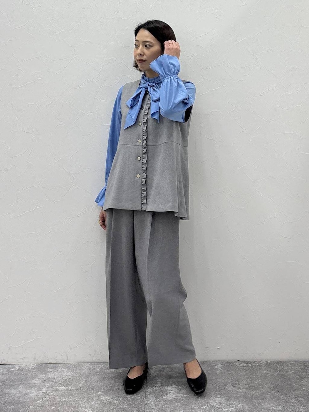 ブラック系のパンプス、グレー系のその他パンツ、グレー系のベストを着用したレディースの冬コーディネートの2枚目の写真