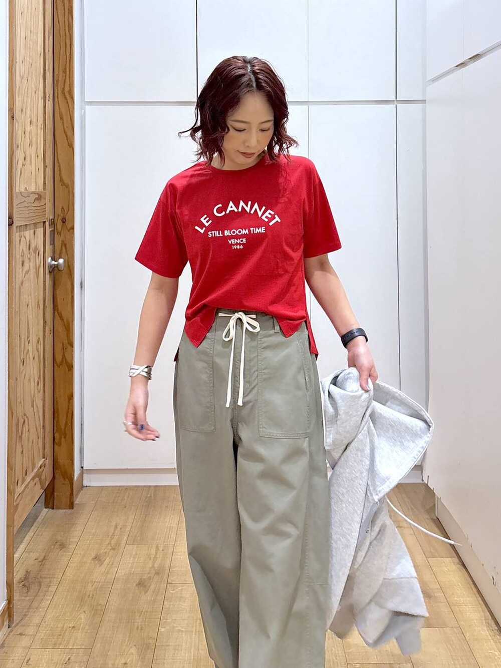 レッド系のTシャツ/カットソー、グリーン系のその他パンツ、グレー系のパーカーを着用したレディースの春コーディネートの9枚目の写真